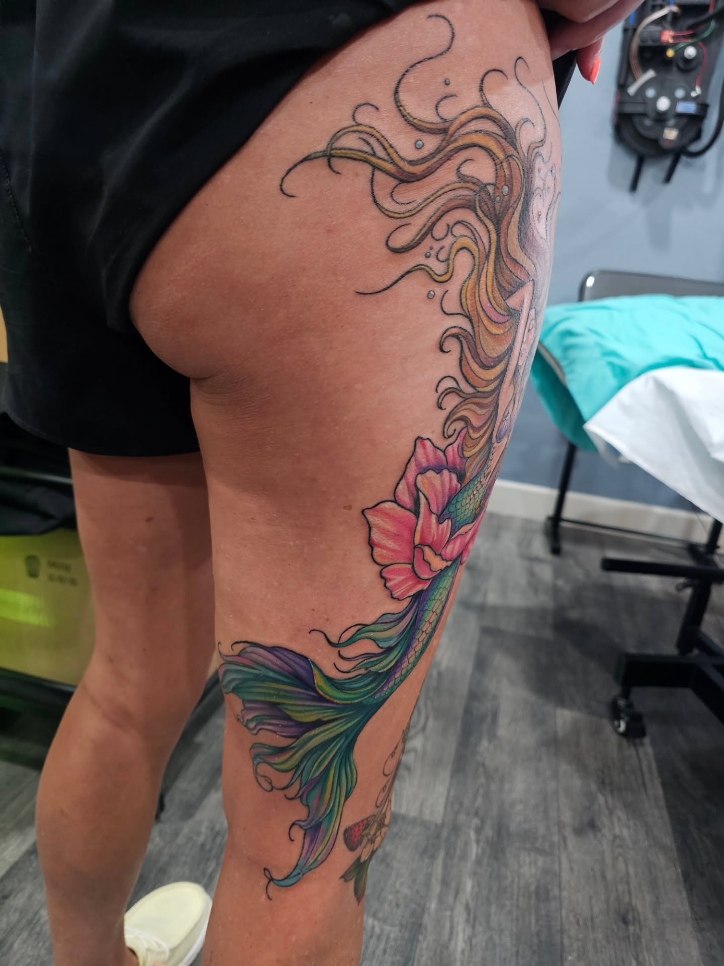 Mermaid tail and flowers new school tattoo on the thigh by Matthew Ashmore