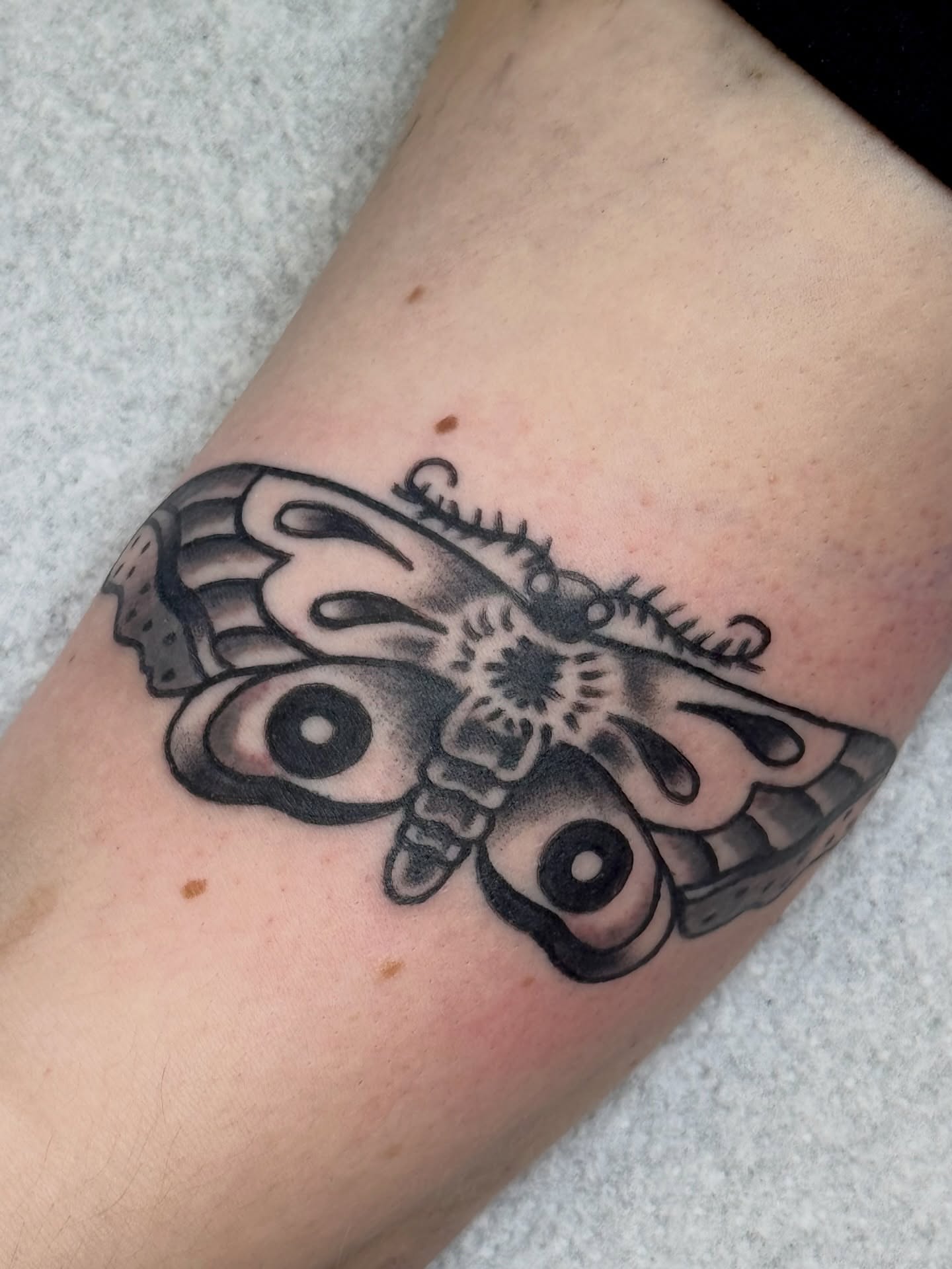 Moth black and grey tattoo on the forearm by Erica Mirella