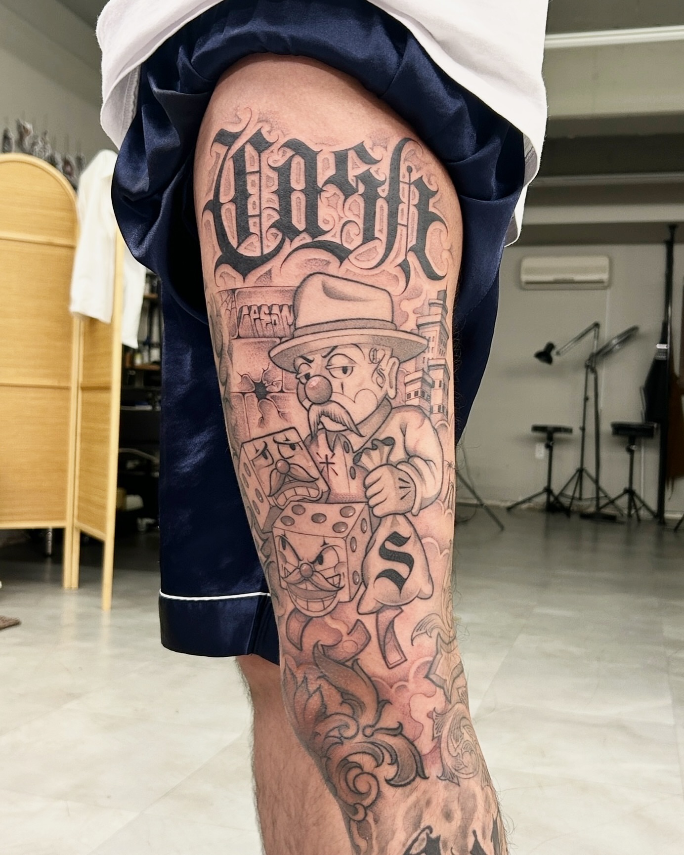 Gangster with dice American traditional tattoo on the thigh by Joon 치카노레터링