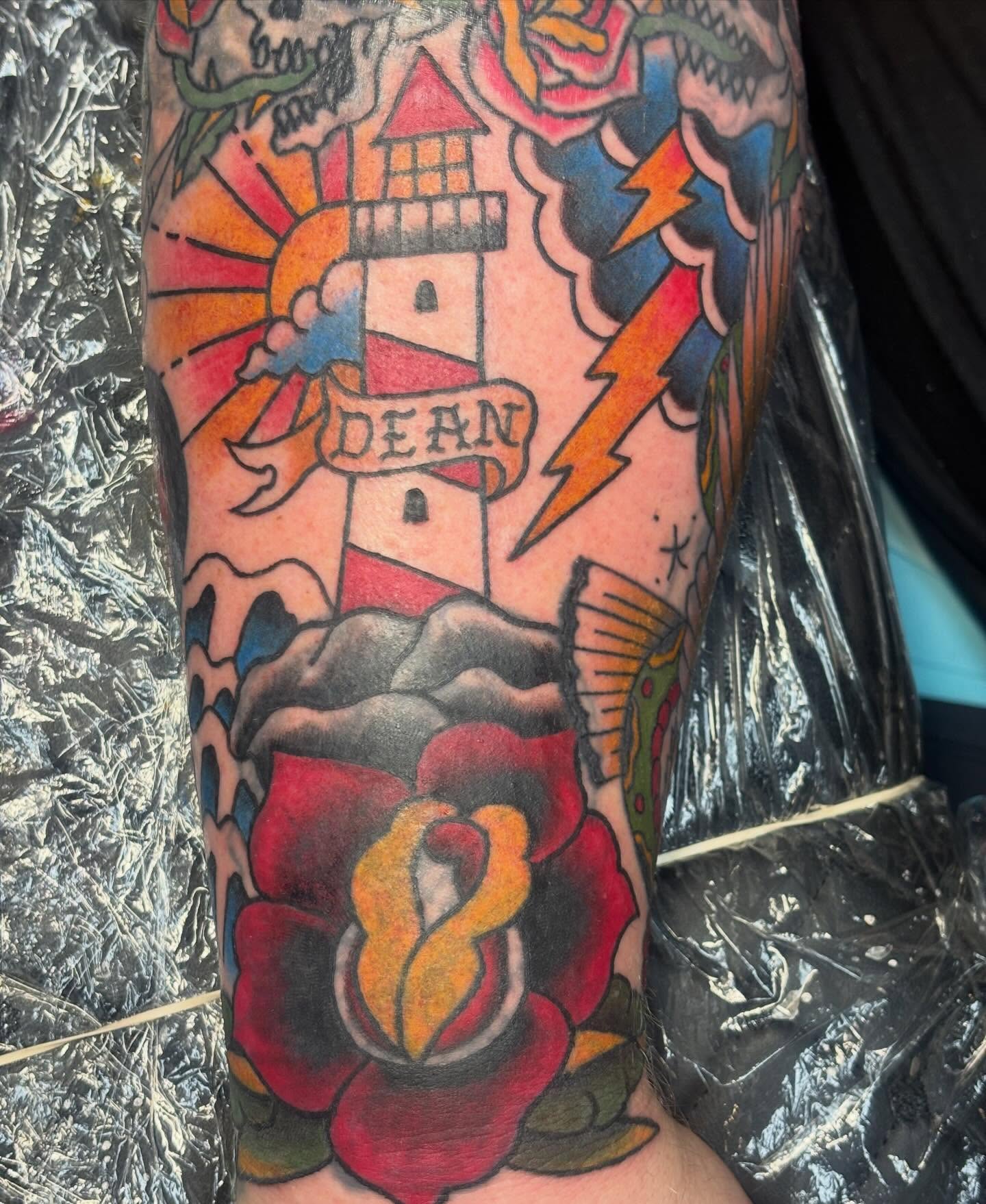 Lighthouse and rose American traditional tattoo on the forearm by Natalie Opal🪻🍎🫖