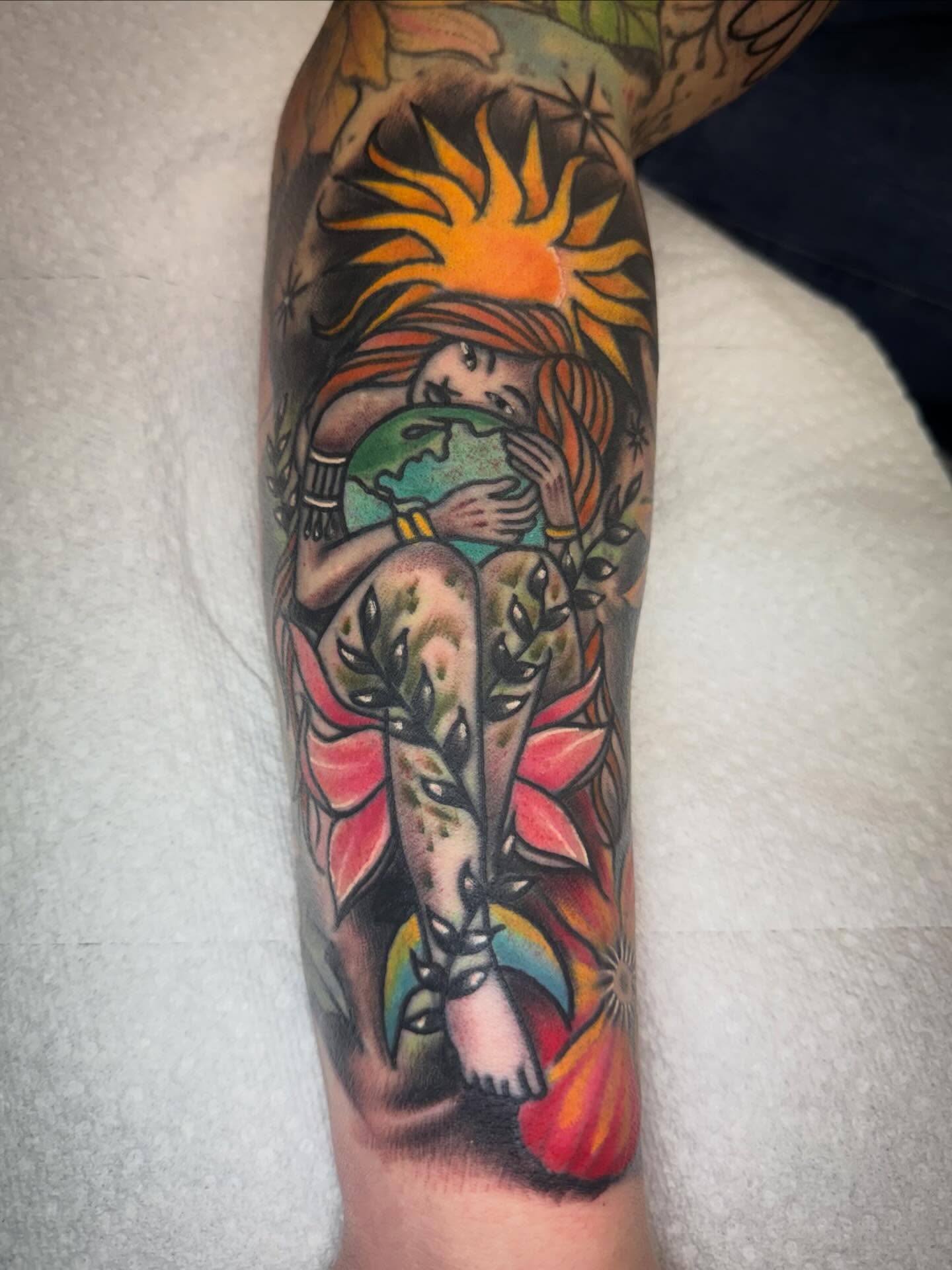 Woman holding globe American traditional tattoo on the forearm by Jake Horstman, Dayton, Ohio