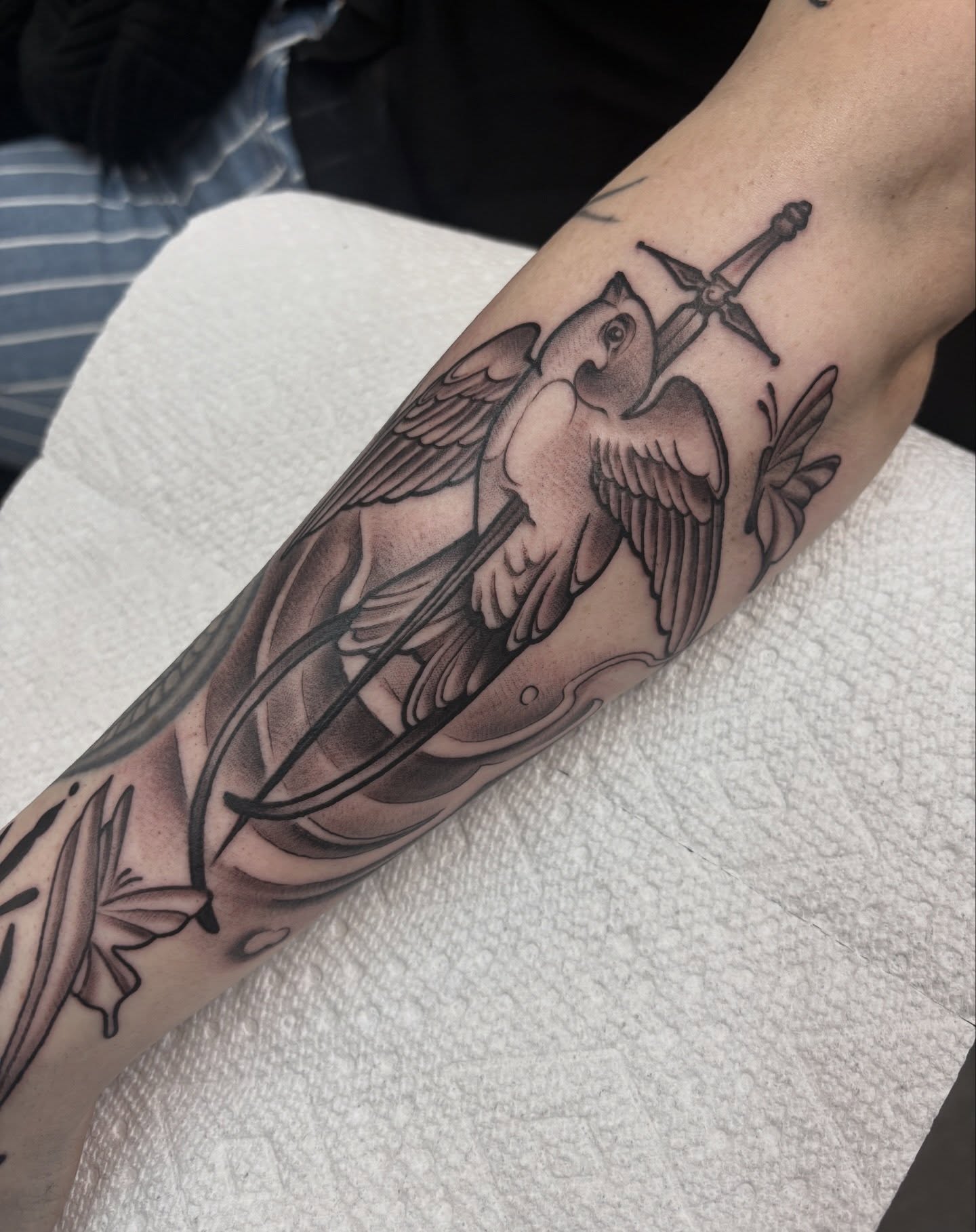 Swallow and sword black and grey tattoo on the forearm by Genevieve Ehlers, Denver, Colorado