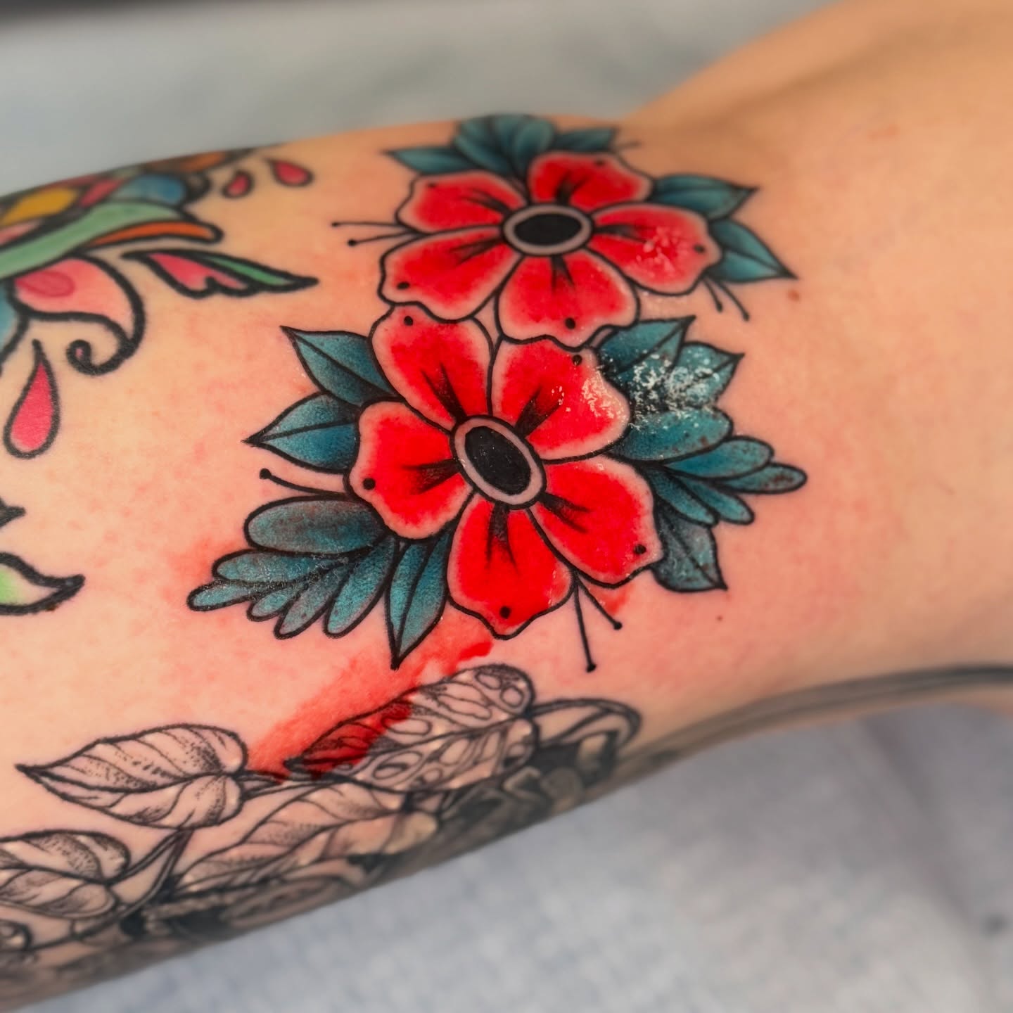 Red flowers American traditional tattoo on the forearm by Chiah