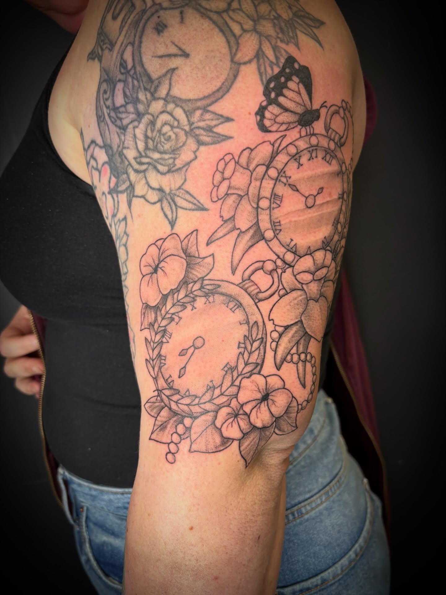 Clocks and flowers realism tattoo on the forearm by Noah Blum
