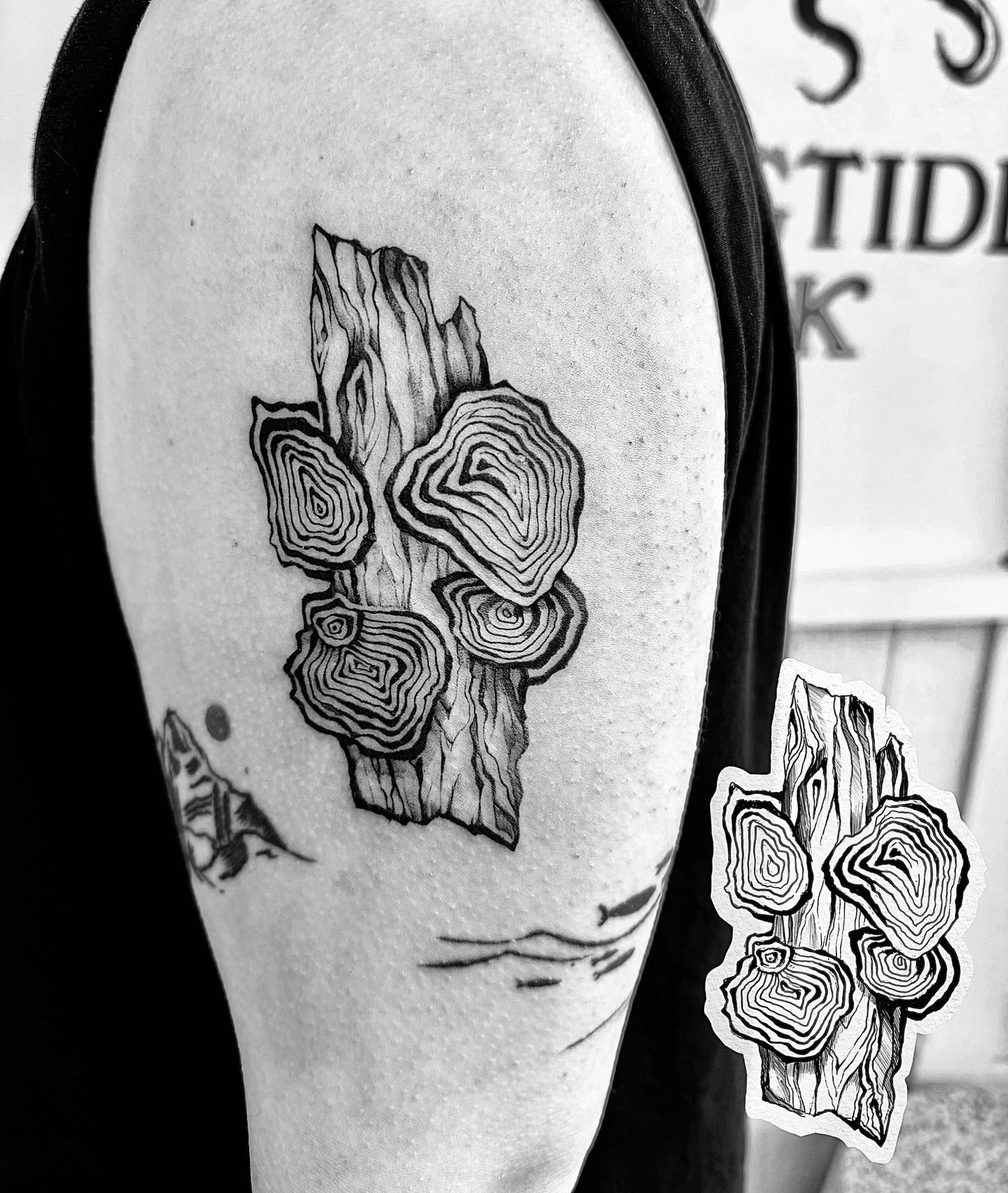 Wood slice black and grey tattoo on the forearm by Kingtide Ink