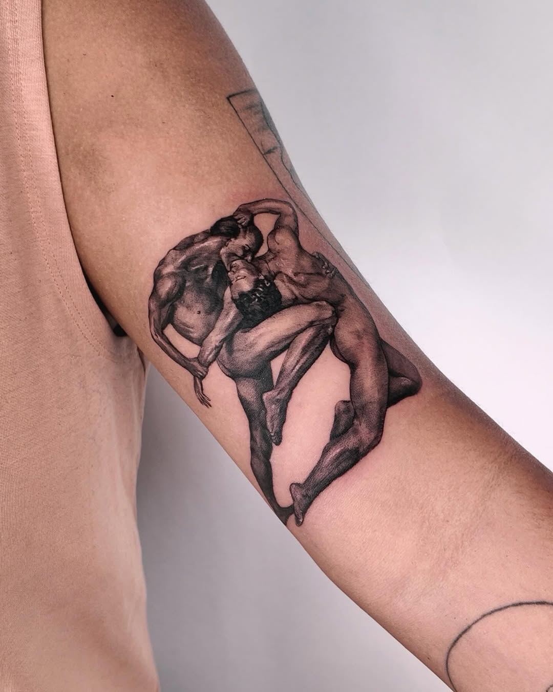 Three figures embracing realism tattoo on the forearm by Gabriel