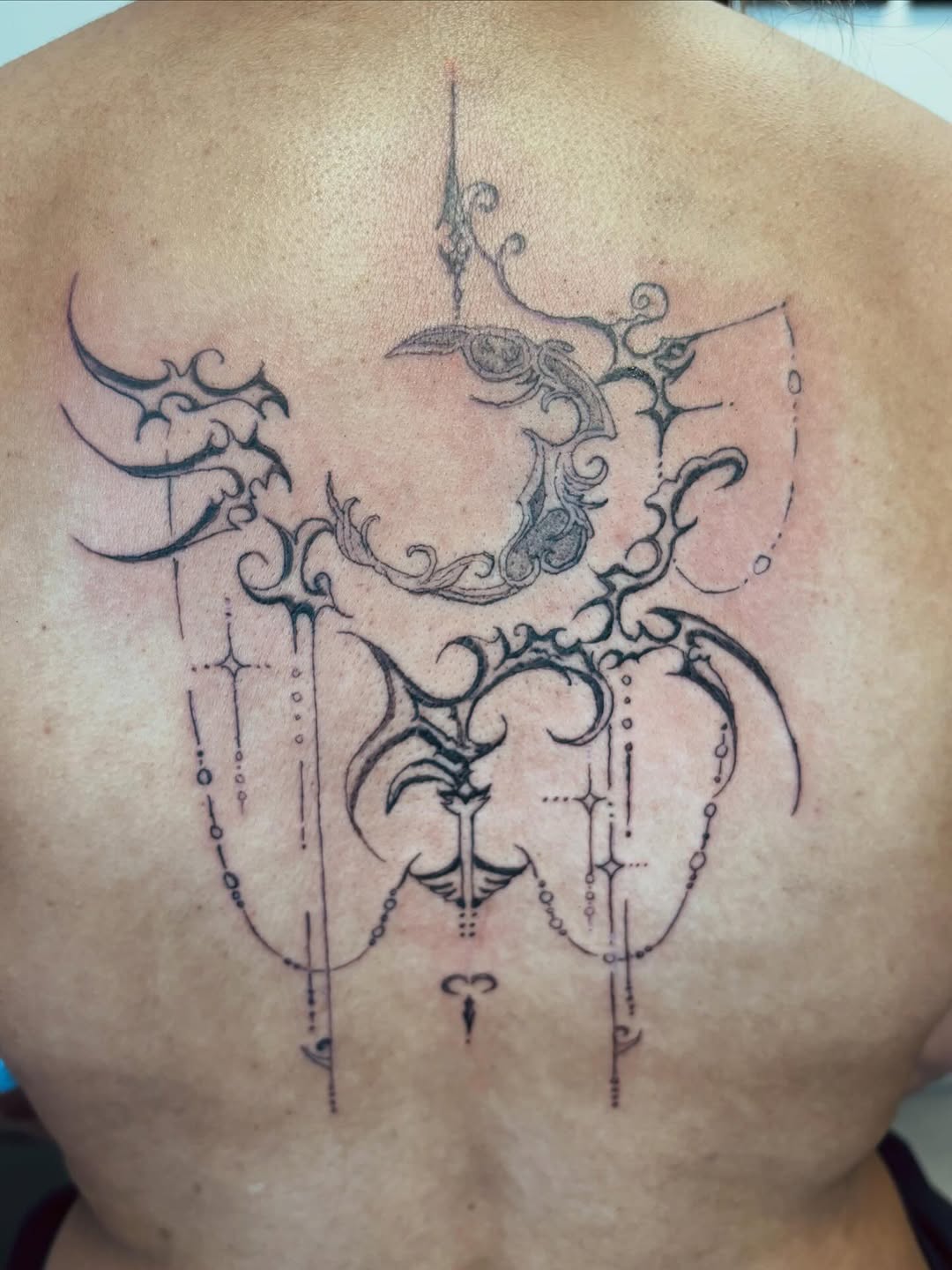 Ornamental moon and celestial elements cyber sigilism tattoo on the back by Lopez Dautruche