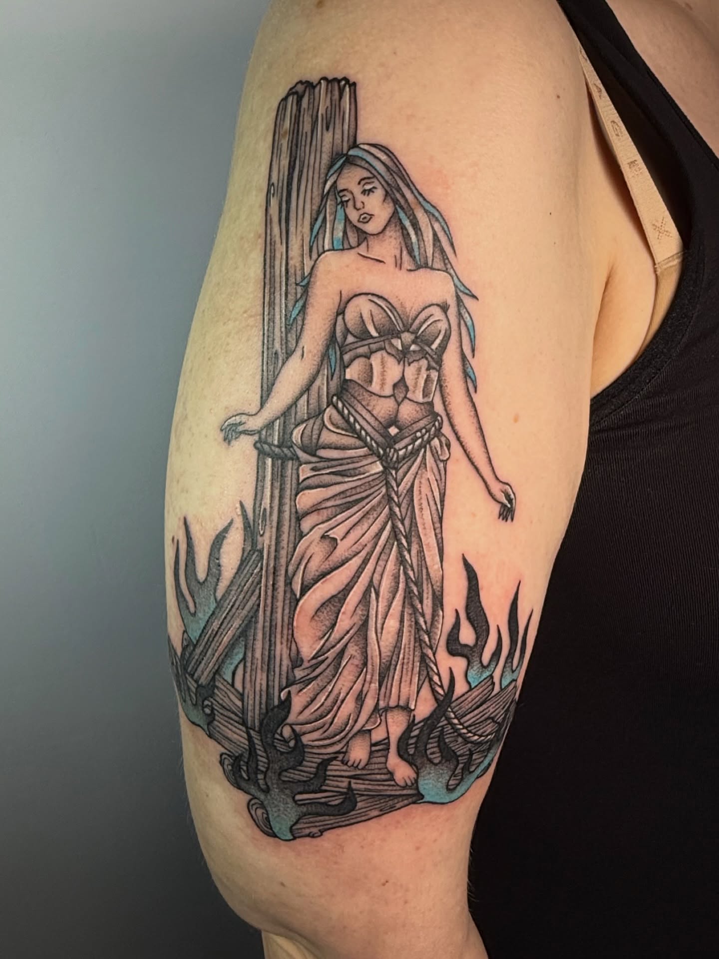 Woman with staff black and grey tattoo on the upper arm by Jenna Nicole