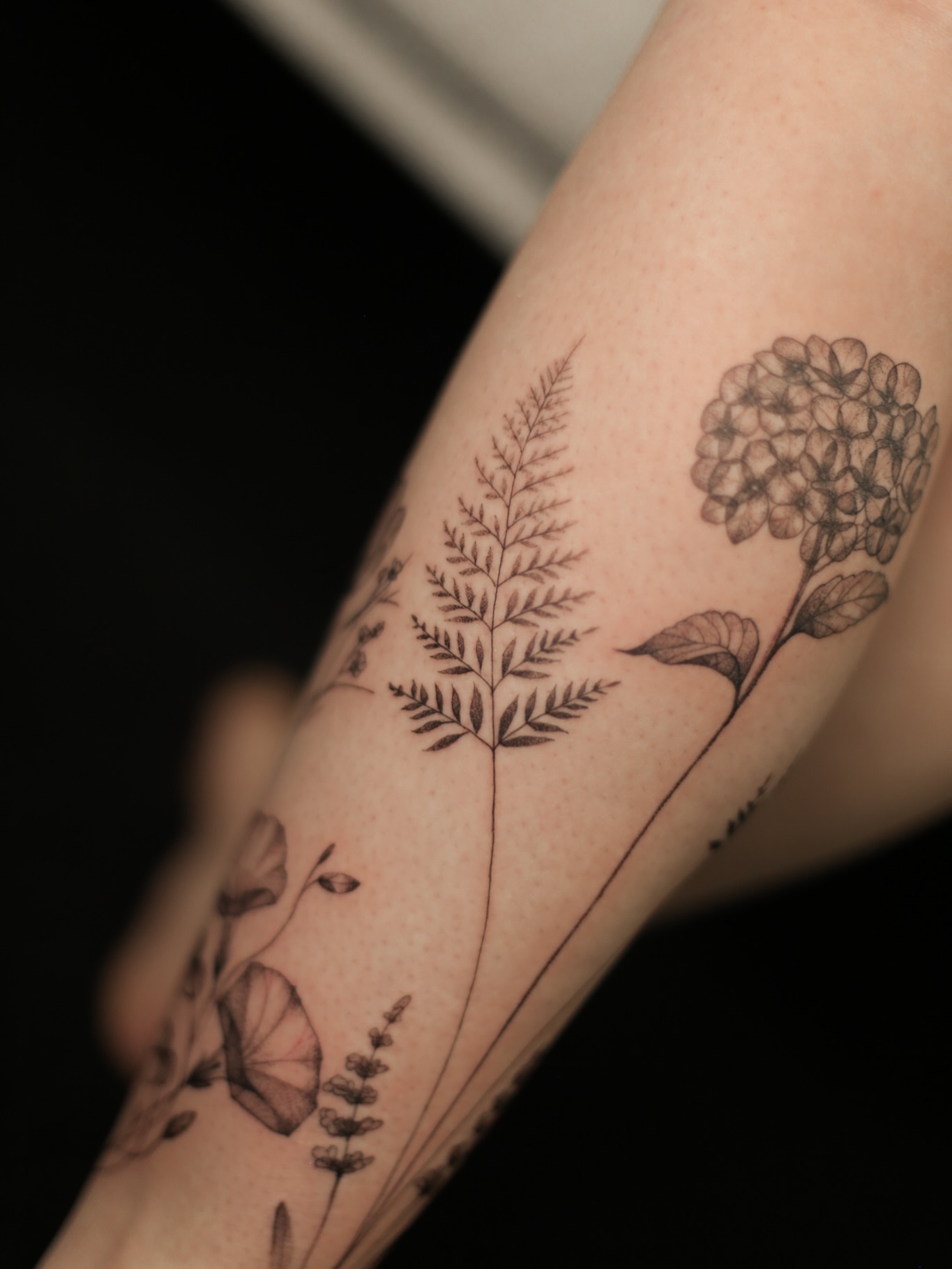 Floral arrangement black and grey tattoo on the forearm by Inna Petrova, Kitchener, Ontario