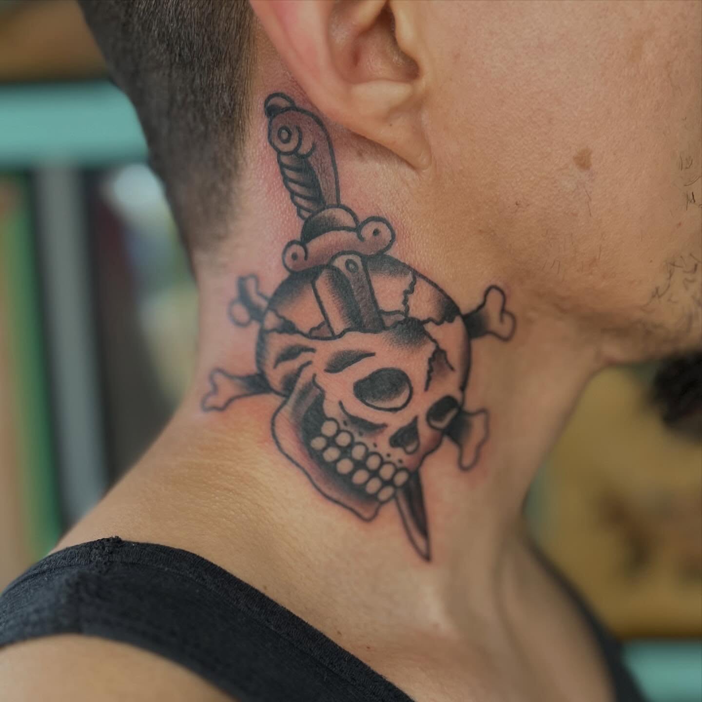 Skull and dagger black and grey tattoo on the neck by Mikey Montoya