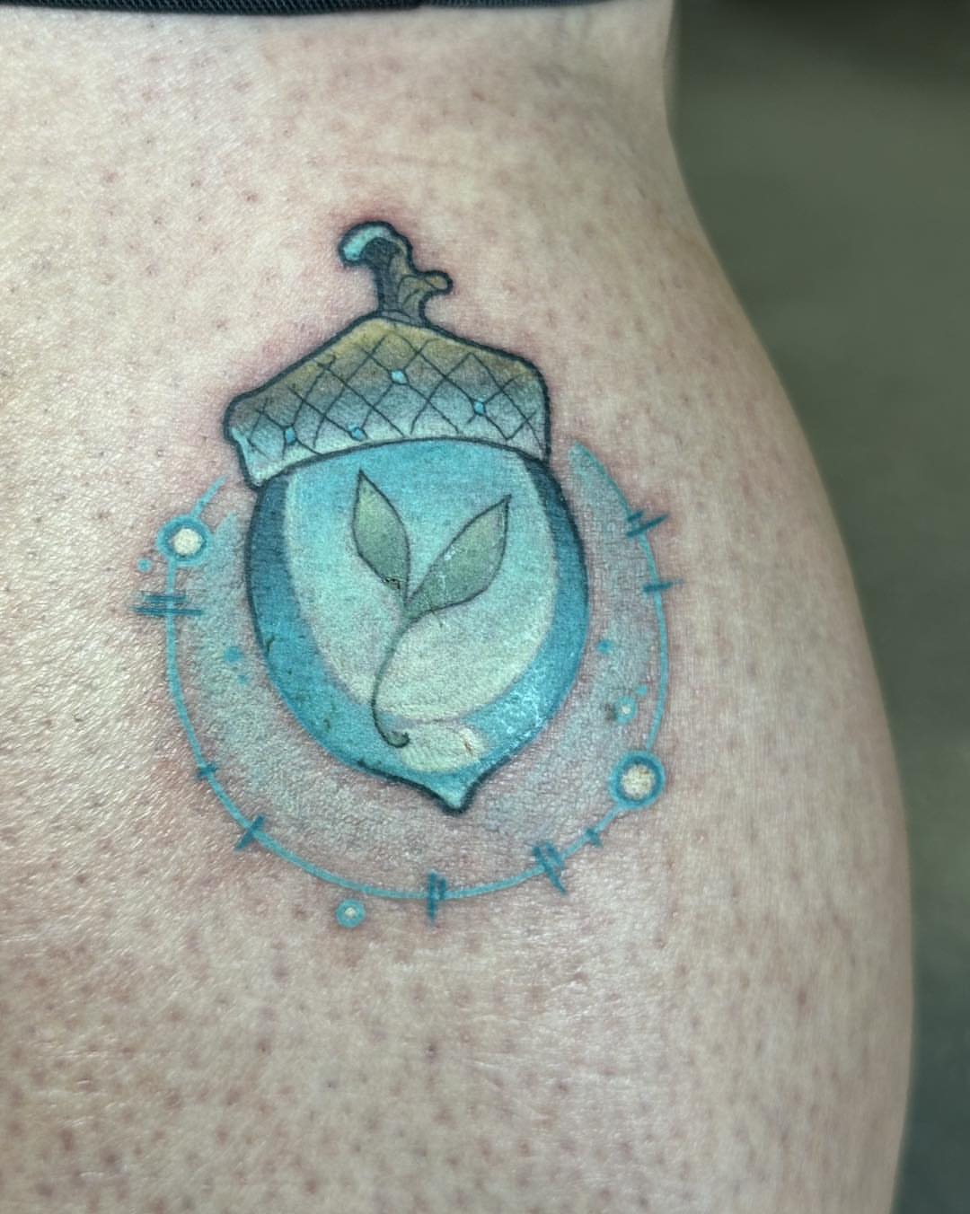 Acorn with sprout dotwork tattoo on the thigh by Harper Clark