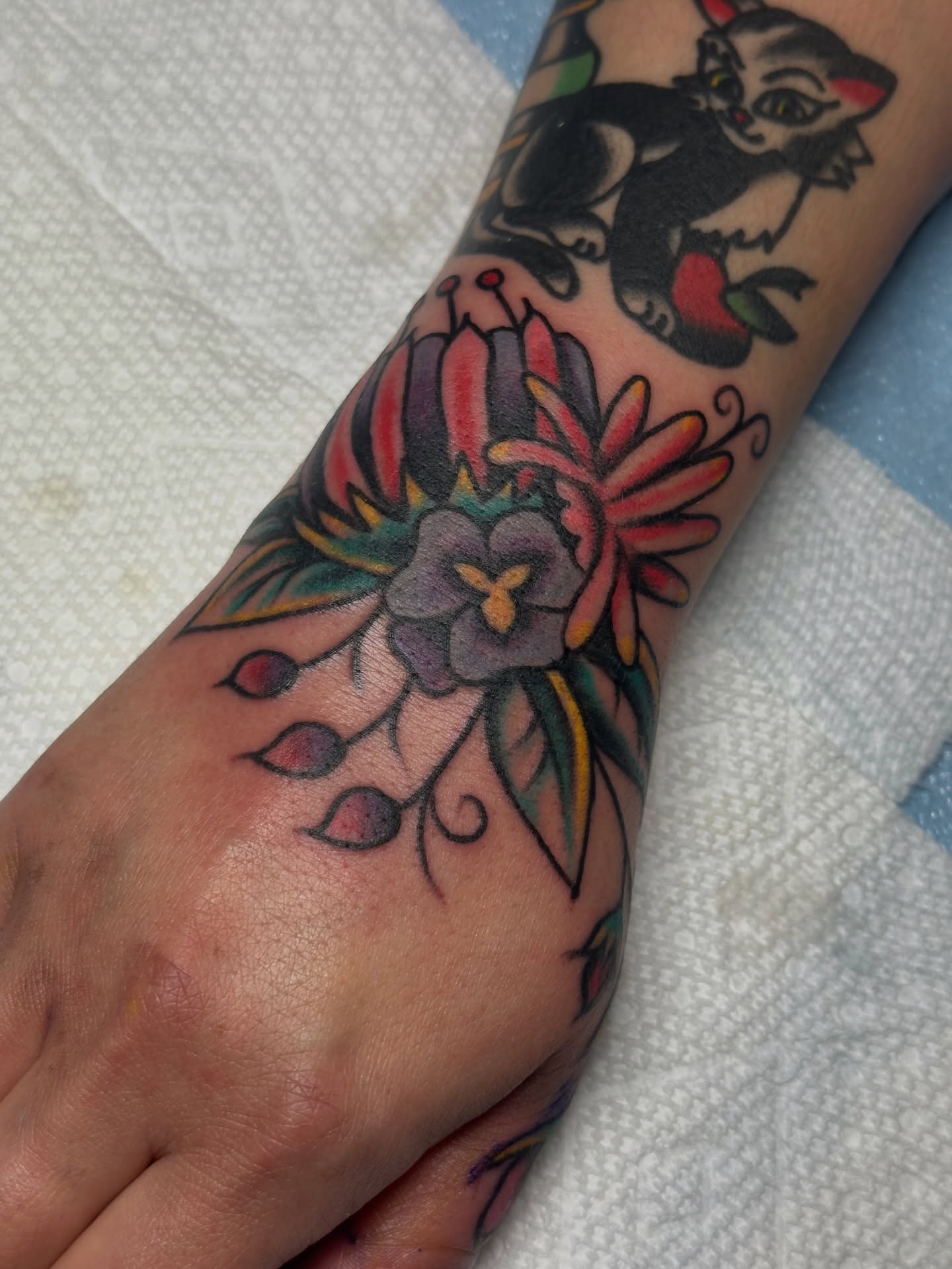 Cat and flowers American traditional tattoo on the forearm by Providence Tattooer