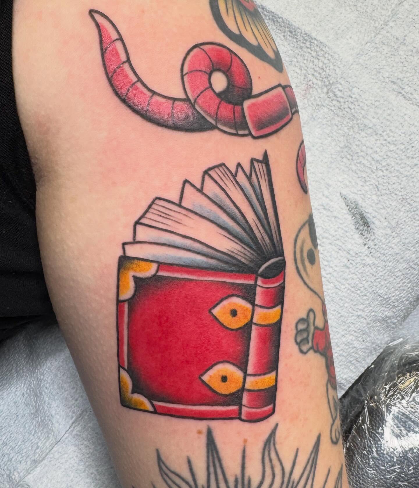 Book with open pages American traditional tattoo on the forearm by Nikki Powills