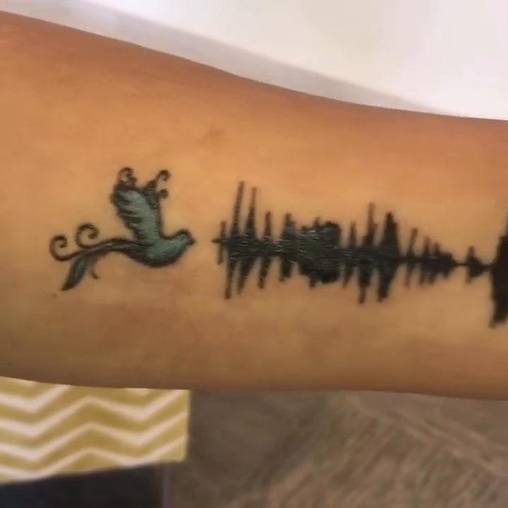 Soundwave with bird fine line tattoo on the forearm by Rhonda Faber Green