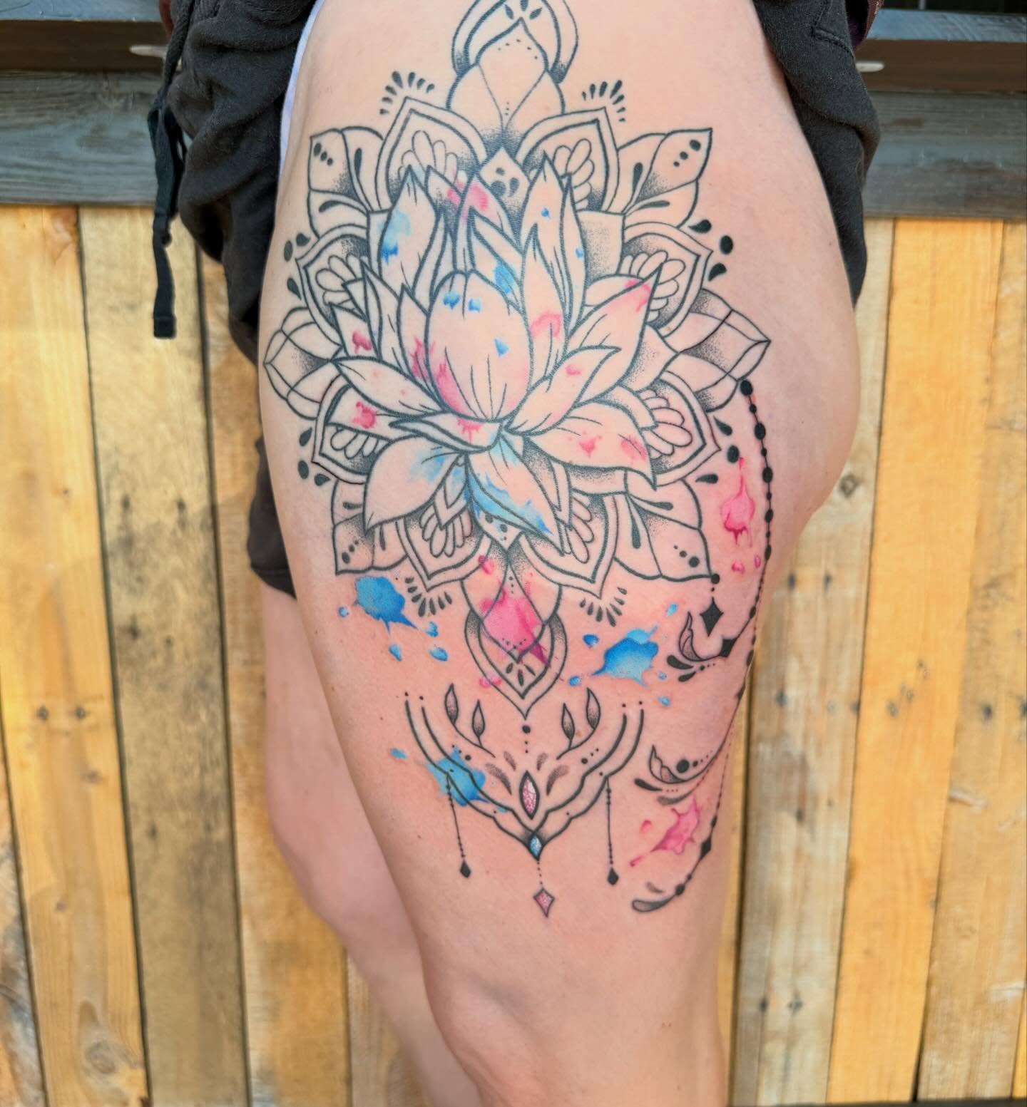 Lotus flower watercolor tattoo on the thigh by Scout Meyer