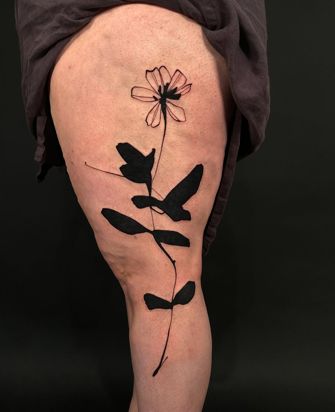 Flower and leaves blackwork tattoo on the thigh by @laurabochet_tattoo, Beacon, NY