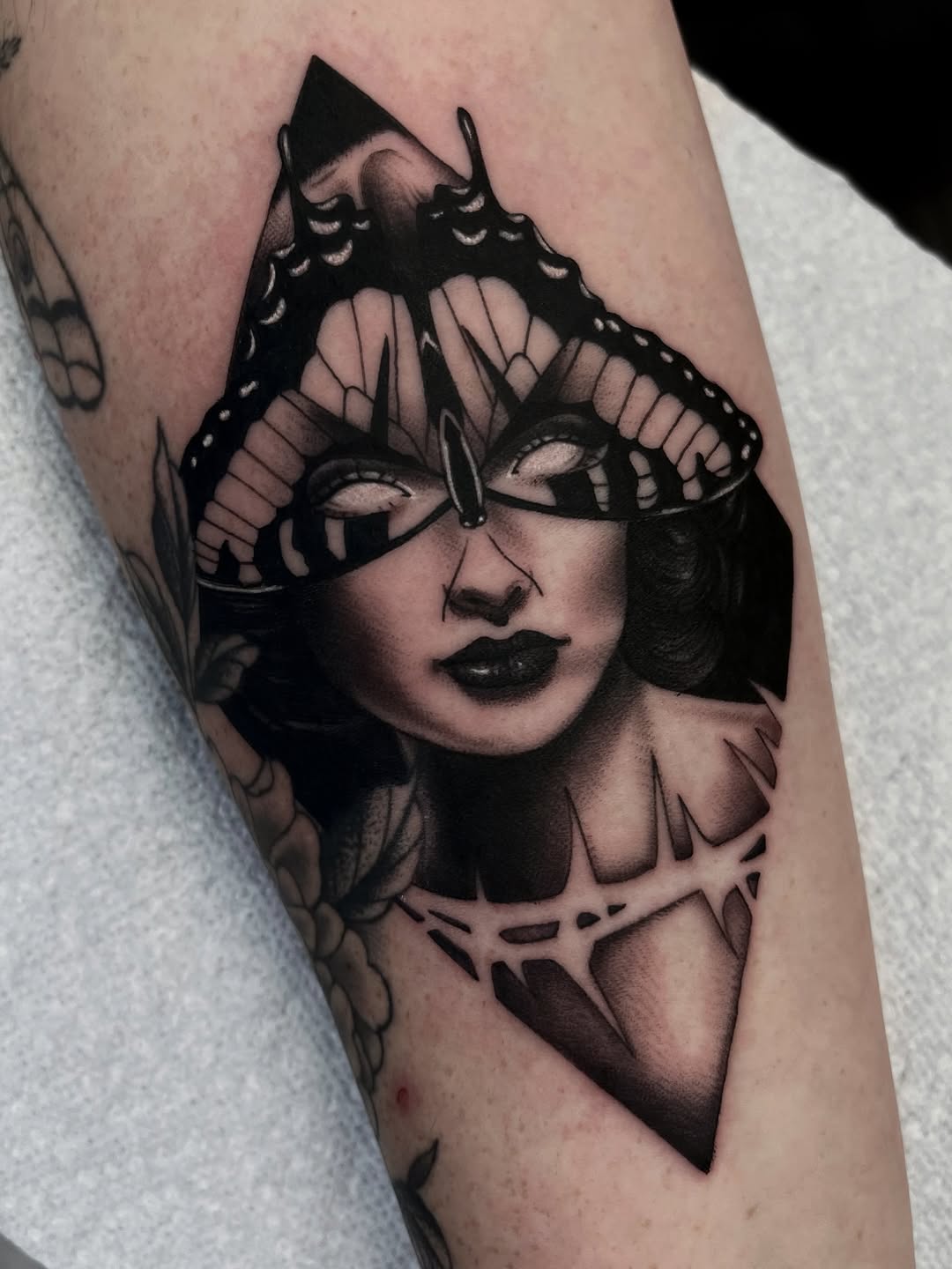 Woman with butterfly mask realism tattoo on the forearm by Sacramento Tattoos (Ilona)