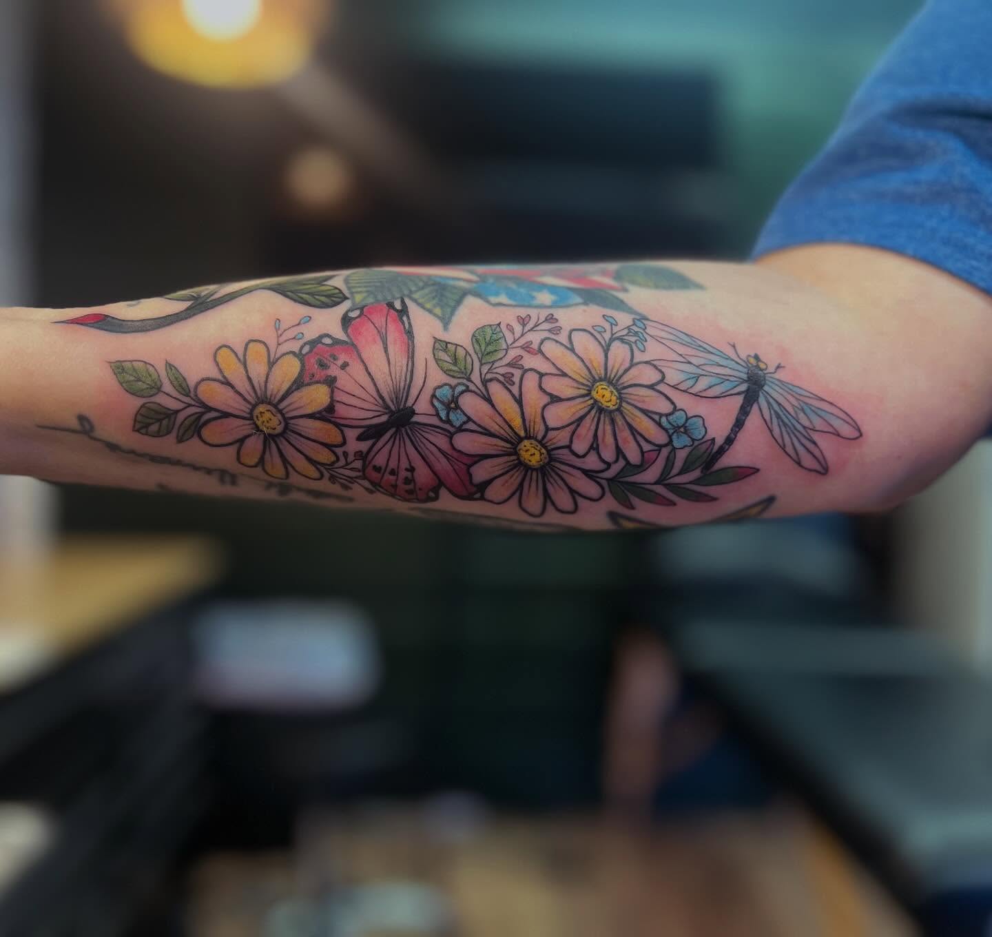 Flowers and dragonfly new school tattoo on the forearm by Victorian Coleman