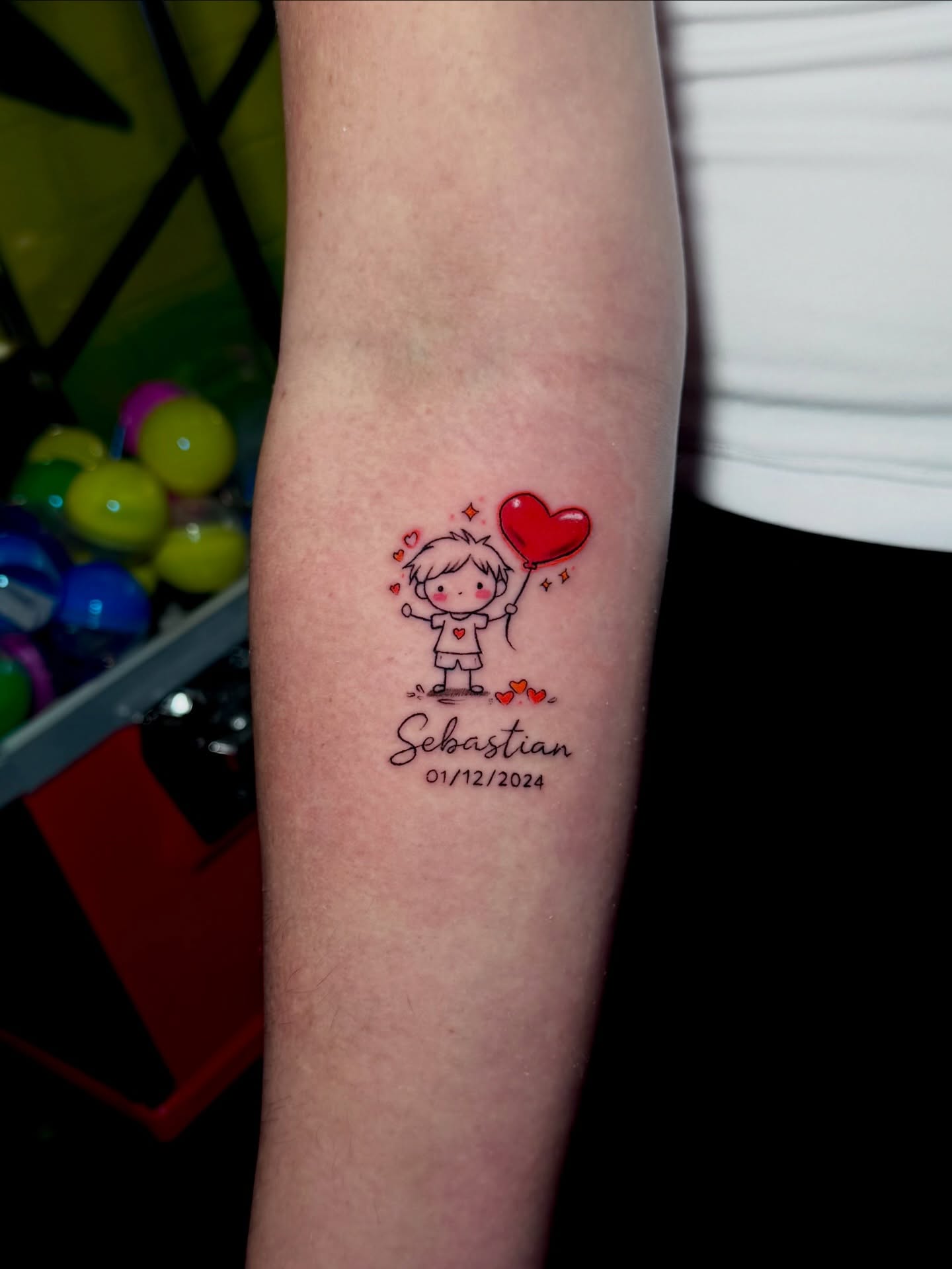 Child with heart balloon illustrative tattoo on the forearm by Keyla Valdes, Miami, Florida