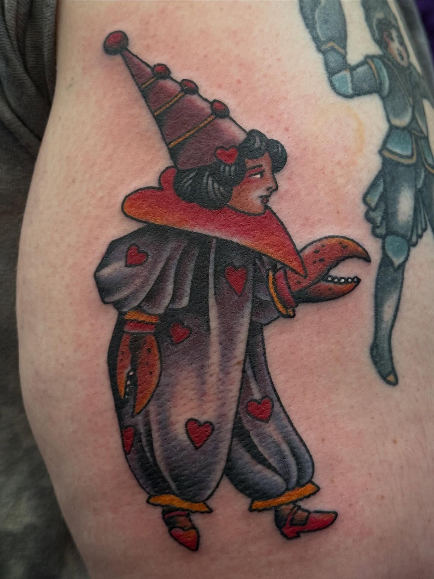 Court jester American traditional tattoo on the upper arm by Laurent Trelaun, San Francisco, California