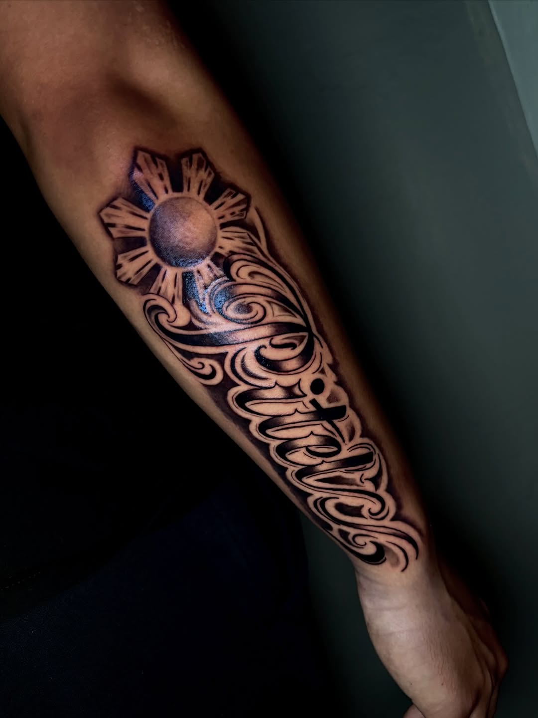 Philippine sun and script lettering lettering tattoo on the forearm by jayla pantig