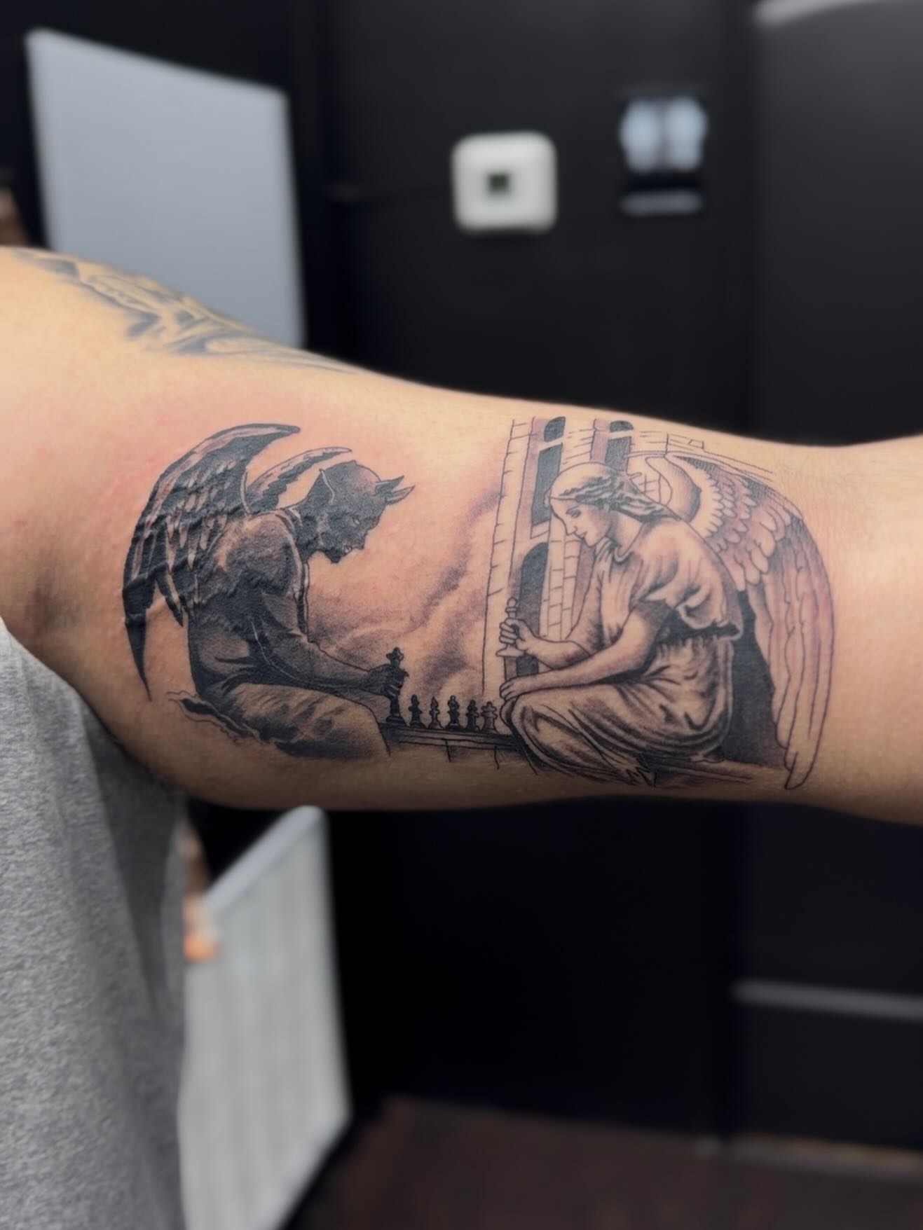 Angel and devil playing chess realism tattoo on the forearm by H.G