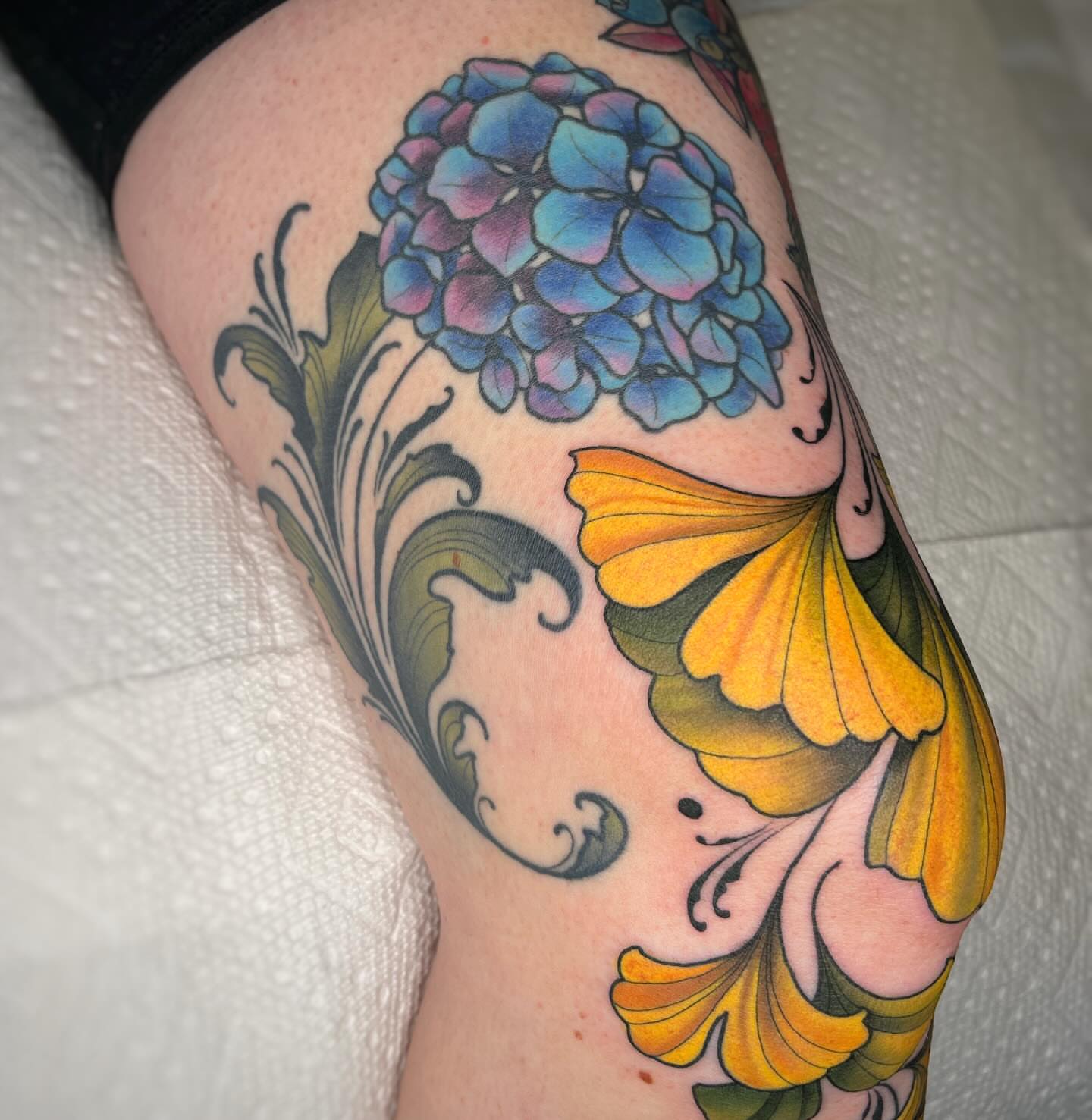 Hydrangea and butterfly American traditional tattoo on the thigh by Emi Collison