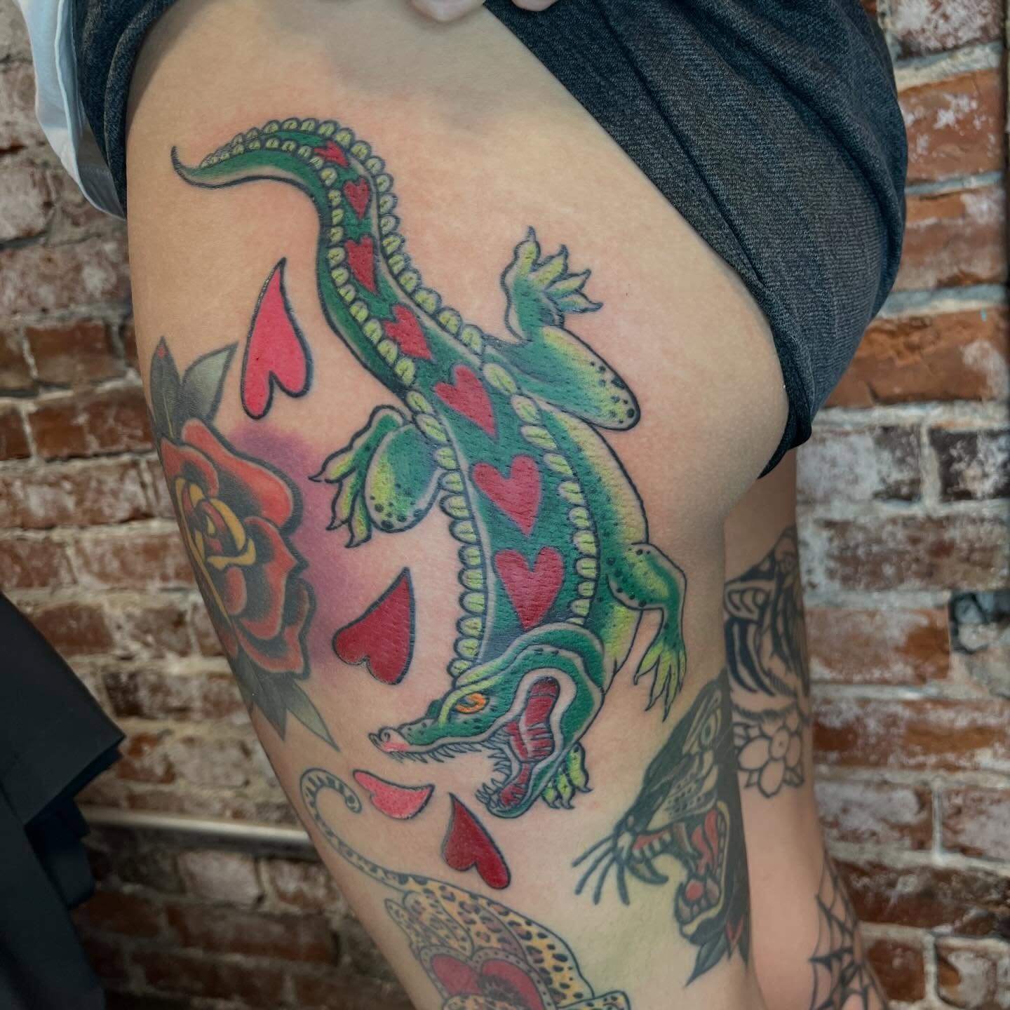 Lizard with hearts American traditional tattoo on the thigh by Evan Voelker