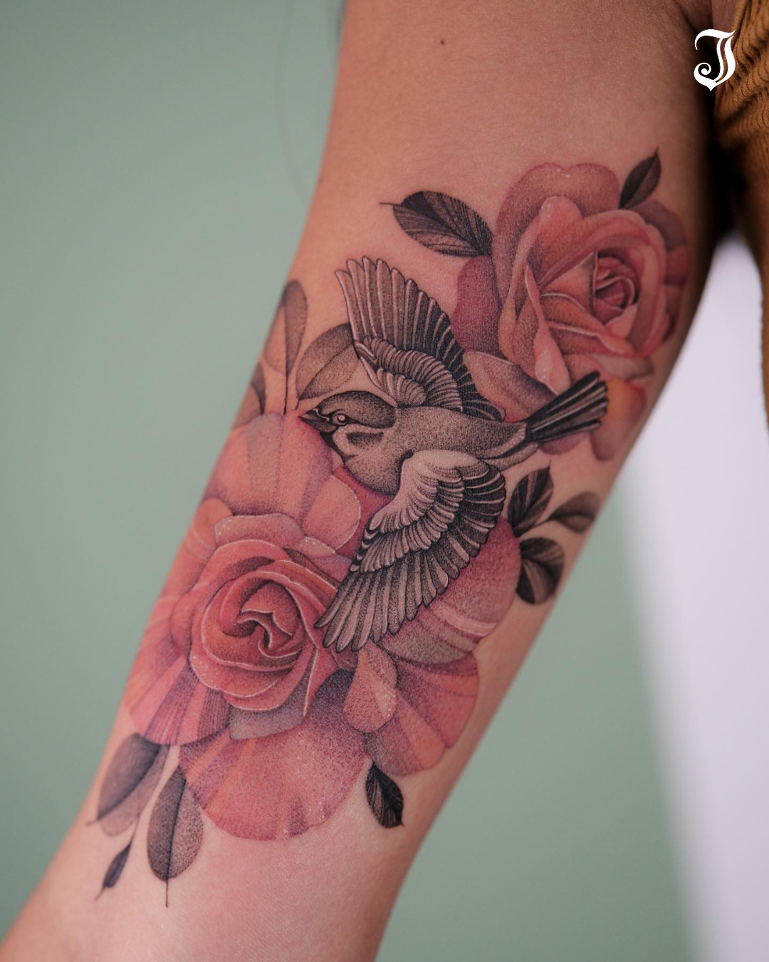 Bird and roses realism tattoo on the forearm by Flower Tattoo Sf
