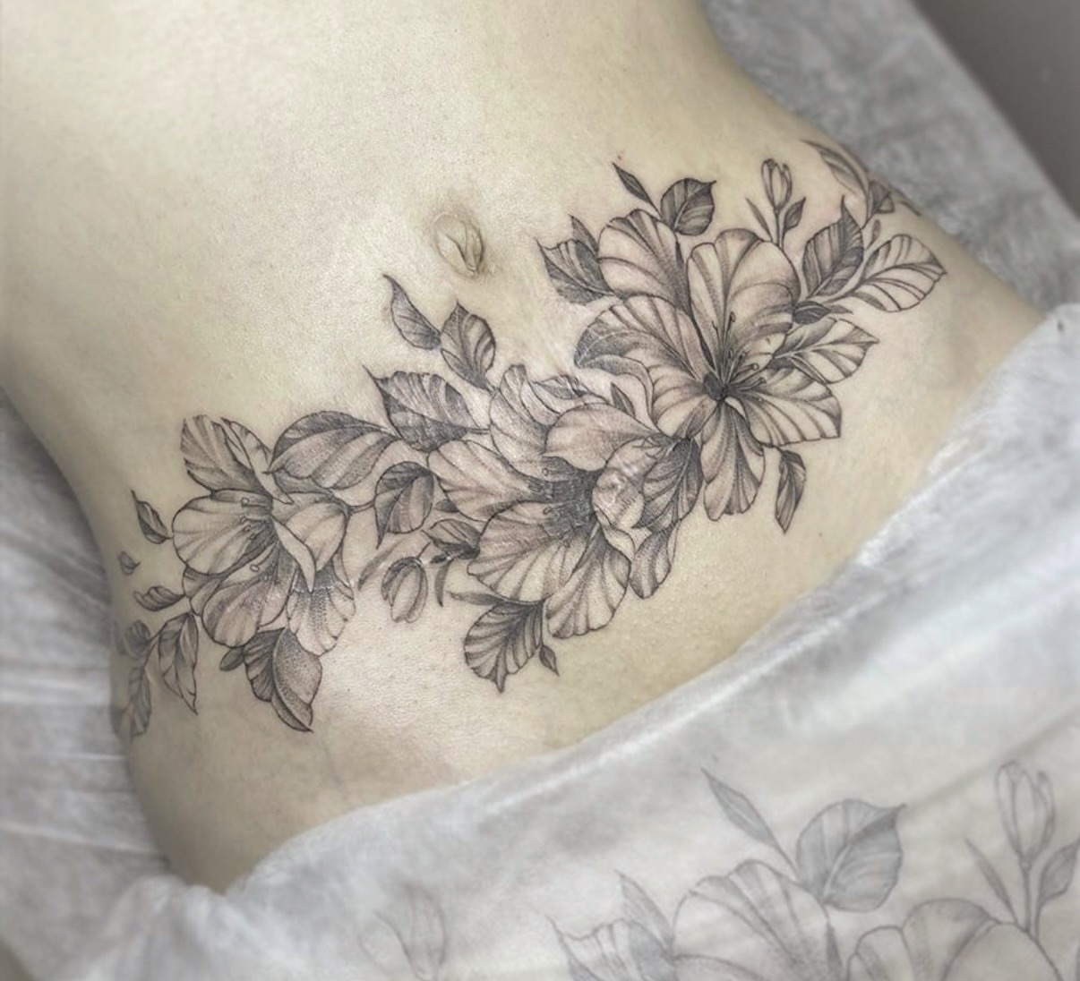 Floral arrangement black and grey tattoo on the ribs by Sacramento tattoo