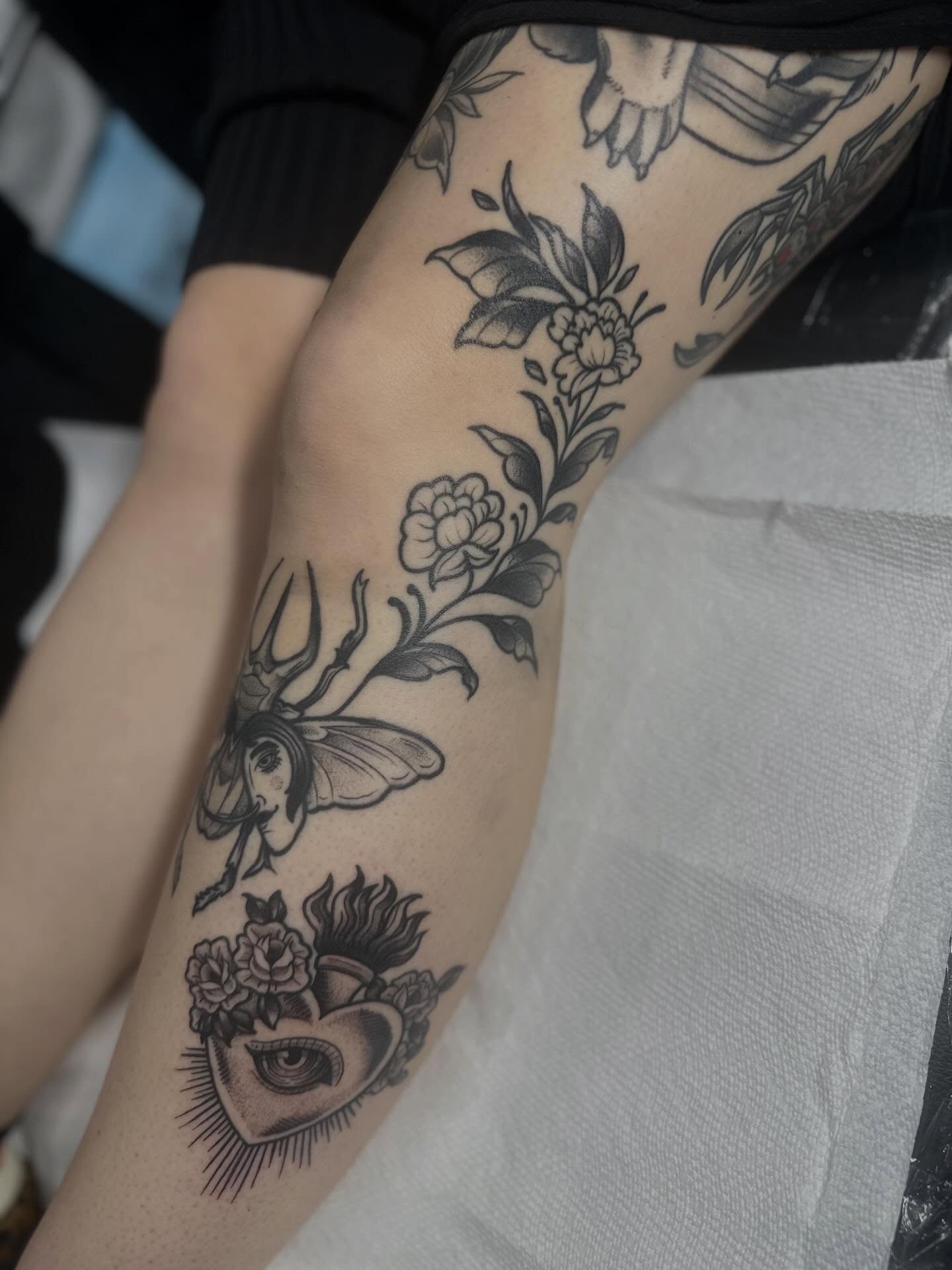 Heart with flowers and insect realism tattoo on the forearm by Dana Smithson-Taylor ๐ณ๏ธโ๐