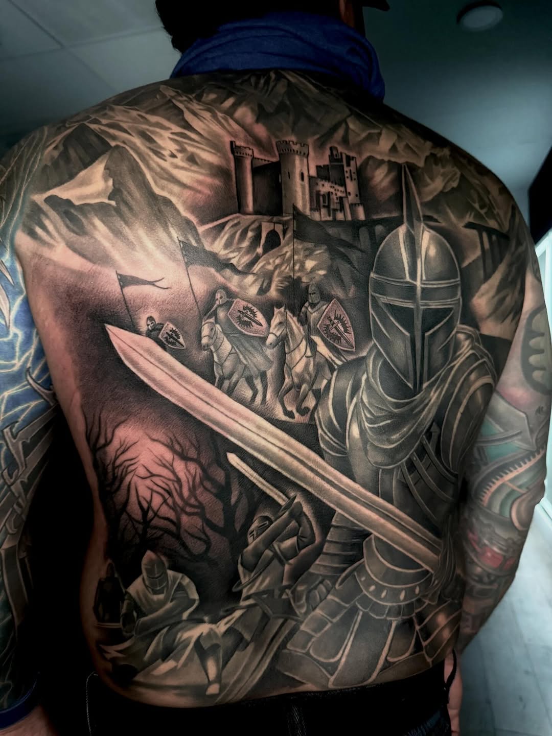 Knights and castle battle scene realism tattoo on the back by DH Tattooing
