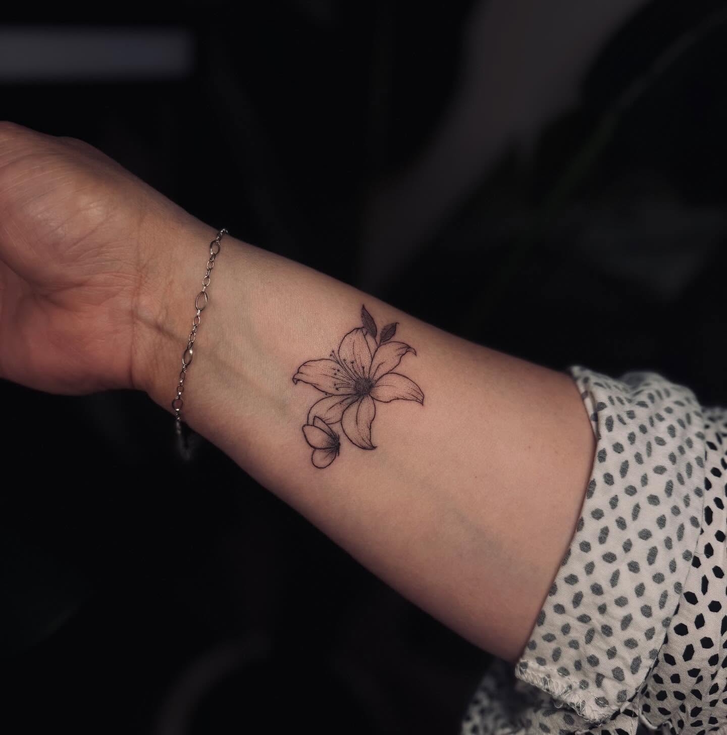 Lily black and grey tattoo on the forearm by Ashley Pilgreen