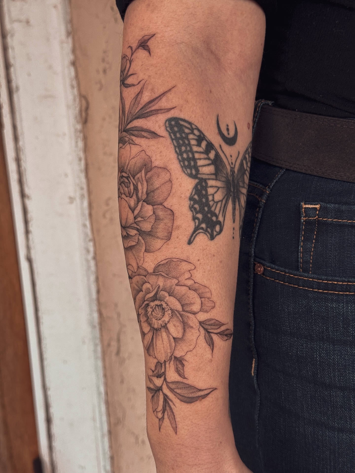 Butterfly and flowers realism tattoo on the forearm by Floral