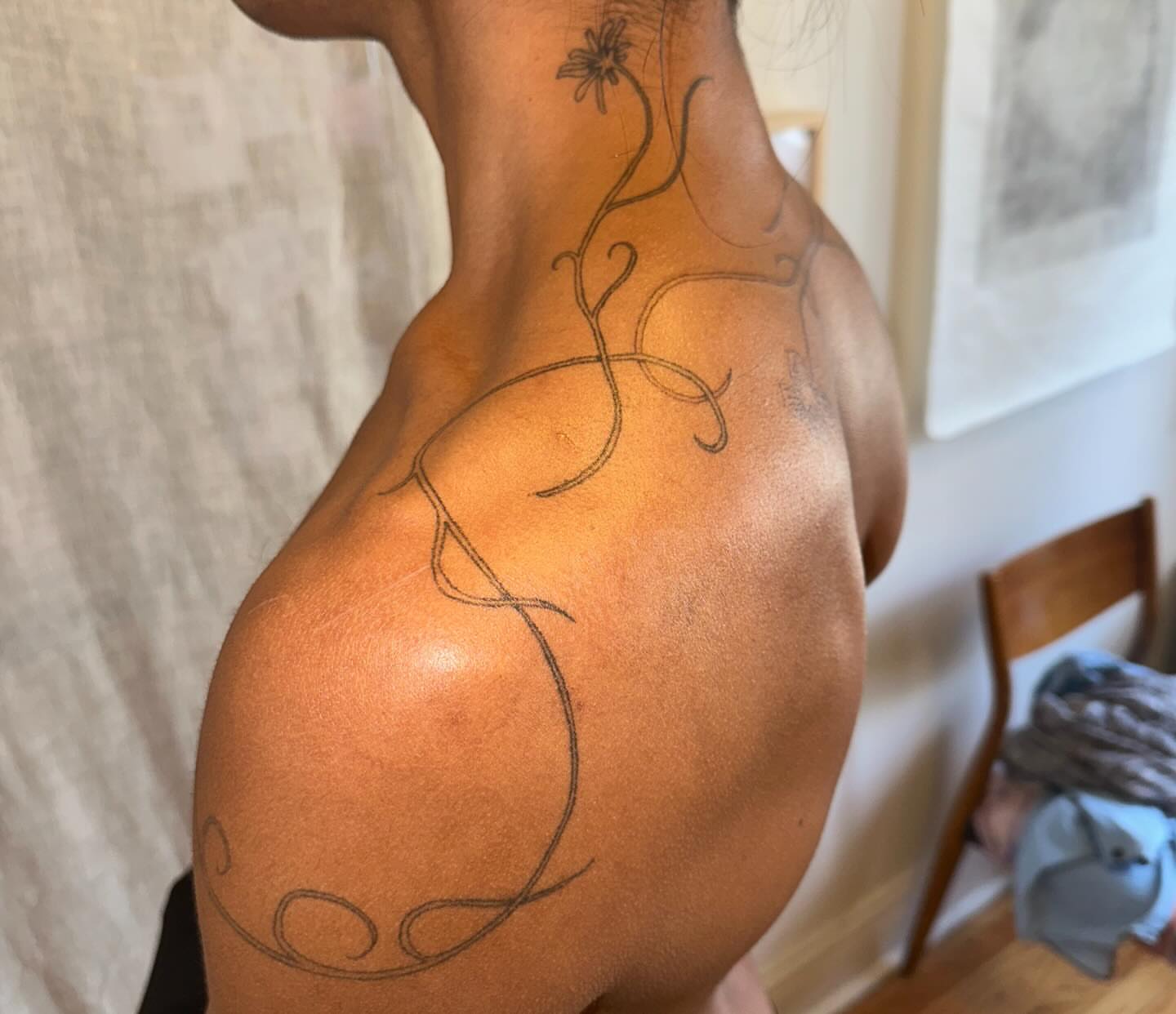 Vines and flower fine line tattoo on the back by kate