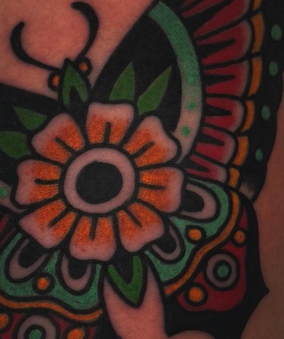 Flower Chicano tattoo on the upper arm by Mikey Sarratt