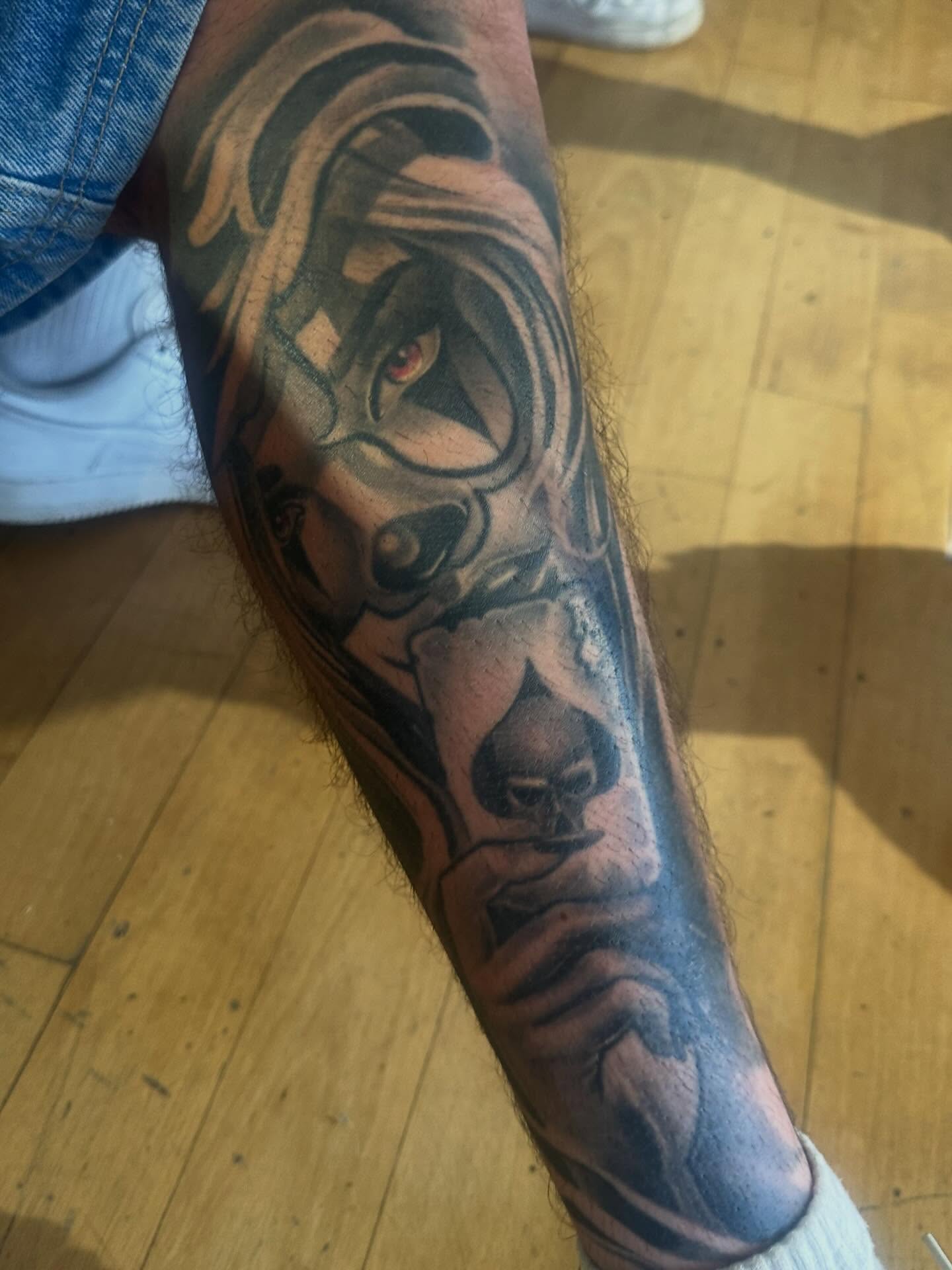 Joker dark realism tattoo on the forearm by Italo Holie