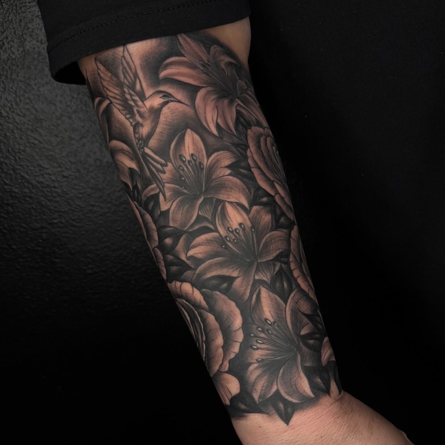 Lilies and hummingbird realism tattoo on the forearm by Elijah East