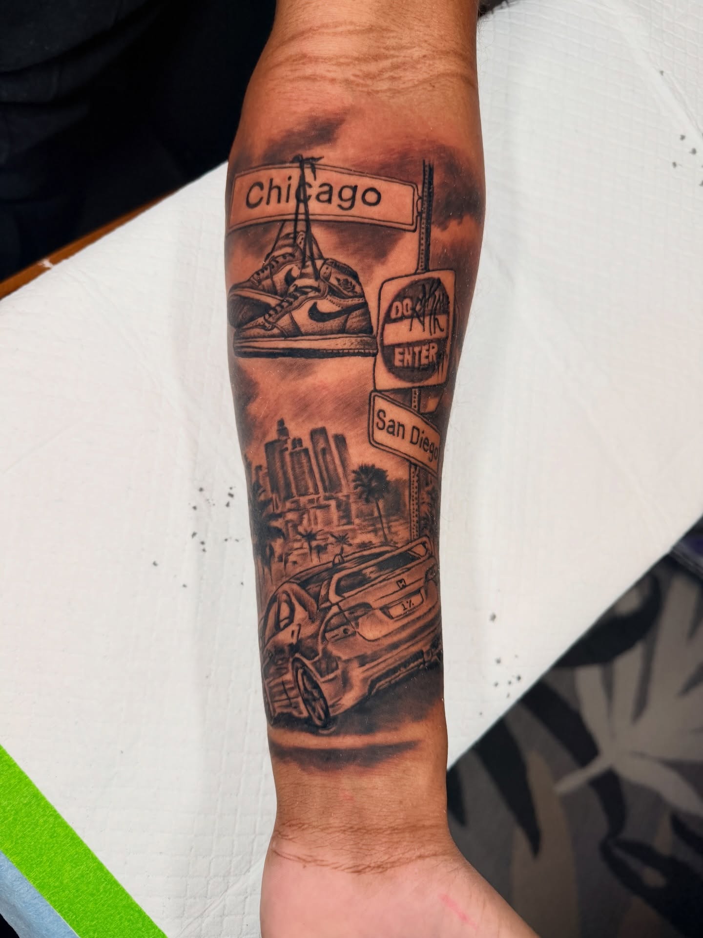 Cityscape and car realism tattoo on the forearm by John Ayson, Murrieta, California