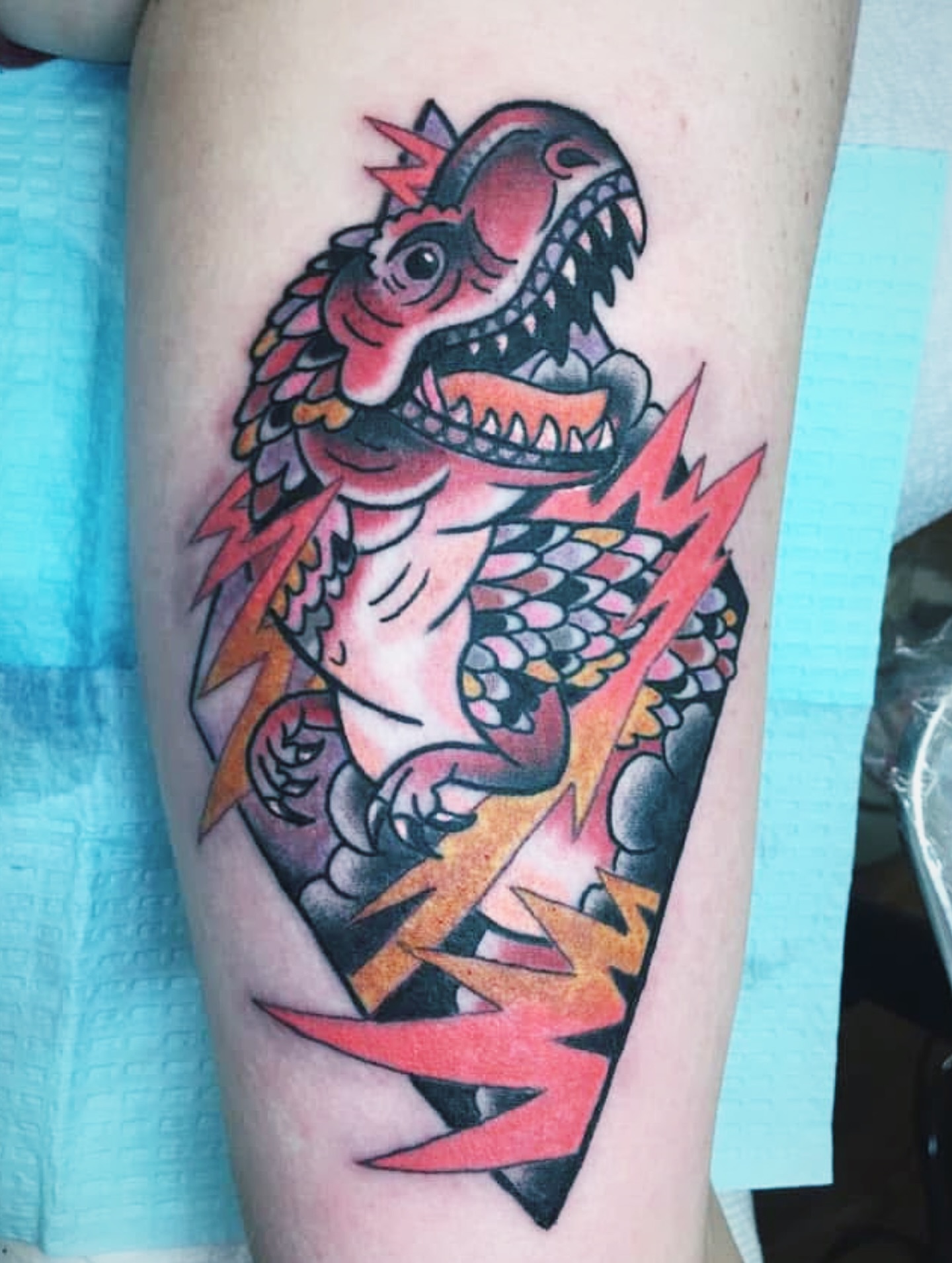Dinosaur American traditional tattoo on the thigh by Aidan Monahan Tattoo