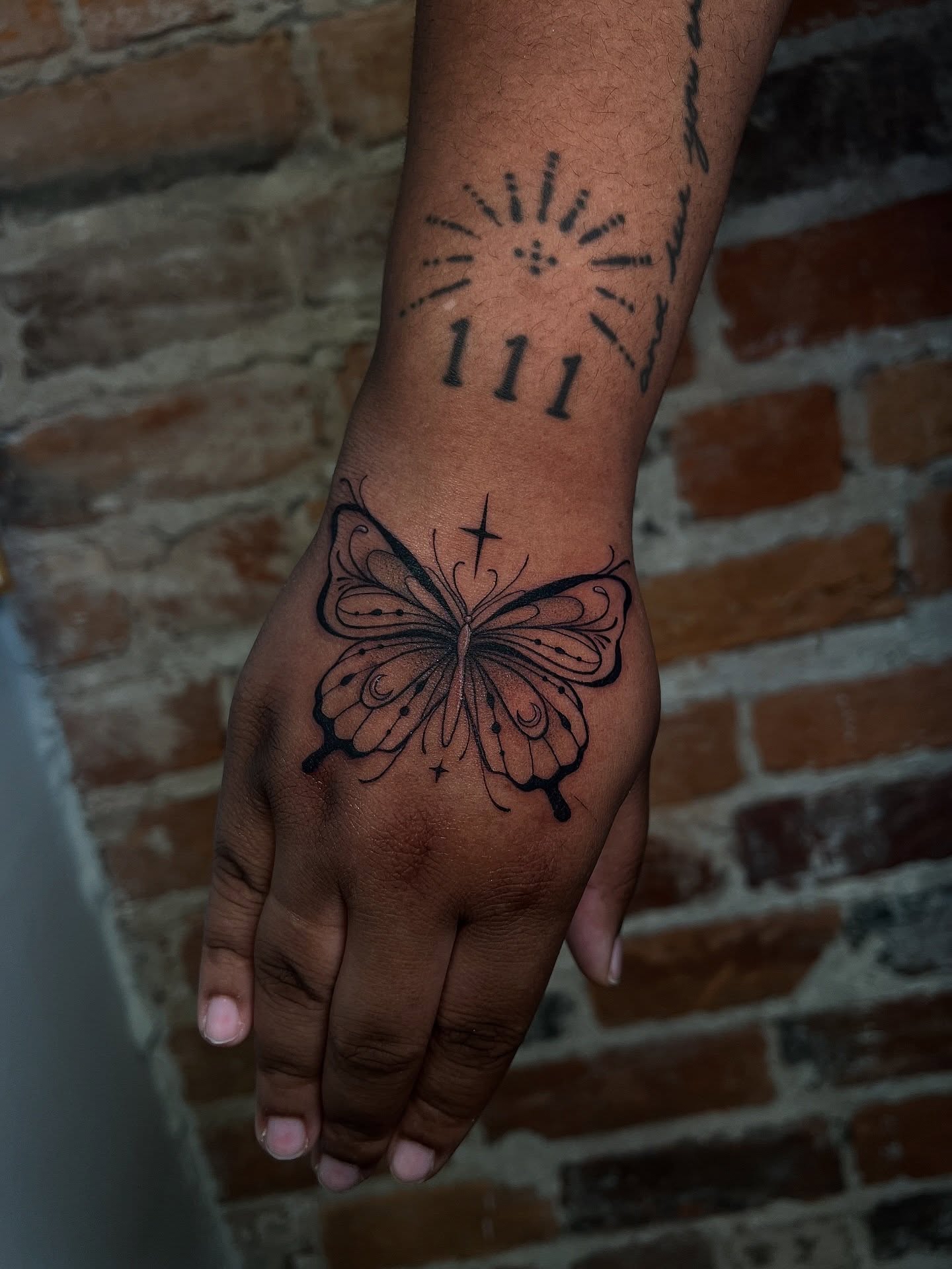 Butterfly black and grey tattoo on the hand by Uncomfy Comfort Tattoos LLC
