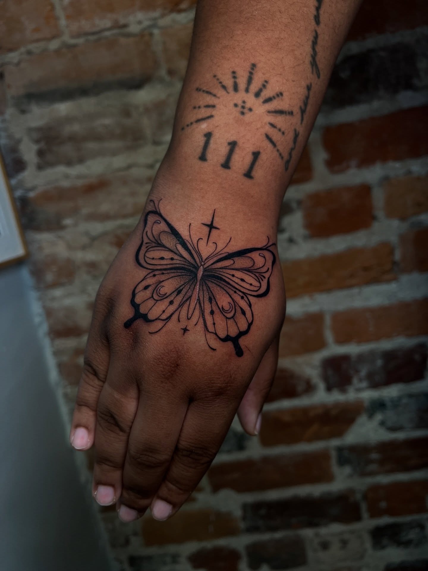 Butterfly black and grey tattoo on the hand by Uncomfy Comfort Tattoos LLC