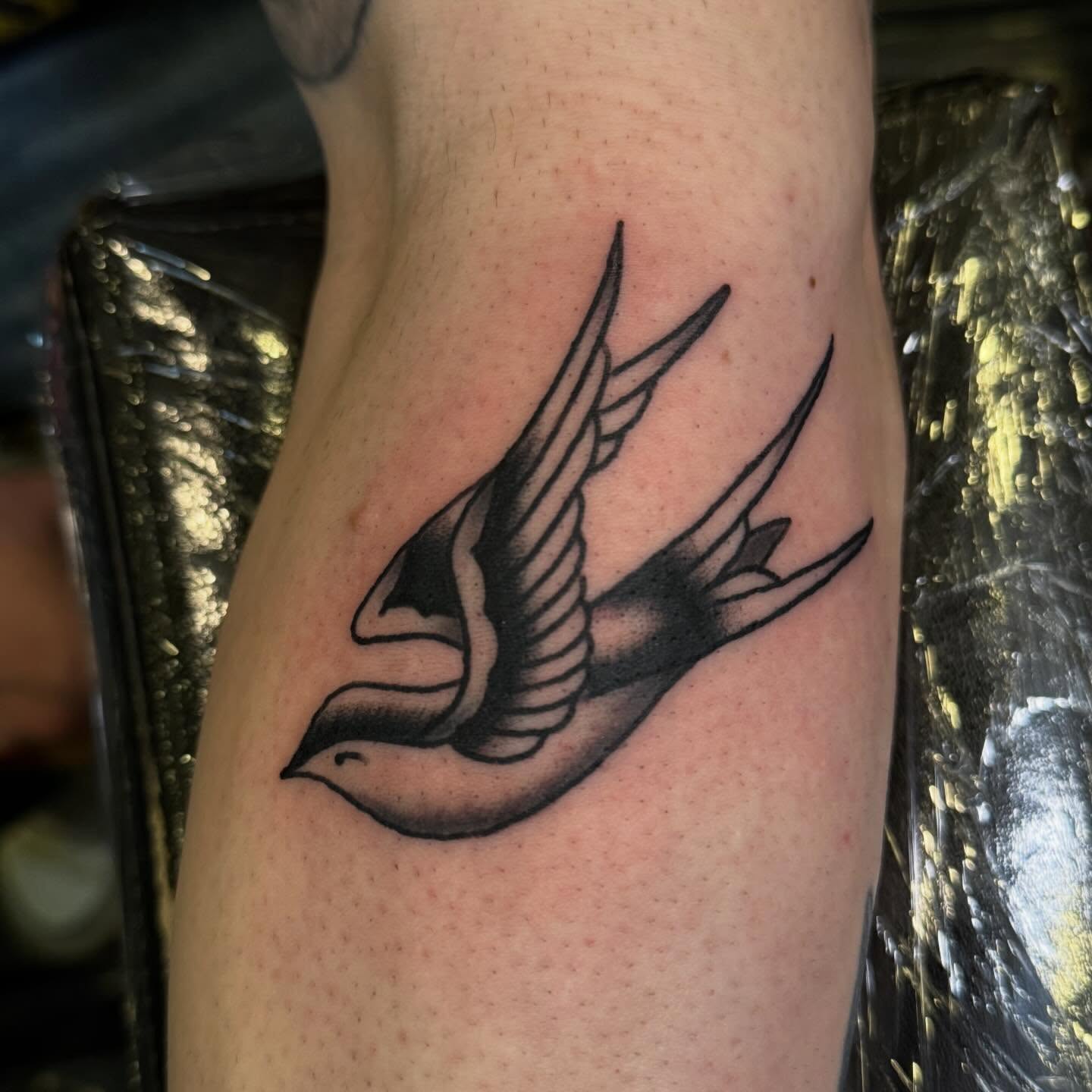 Swallow black and grey tattoo on the forearm by Justin Rakowski