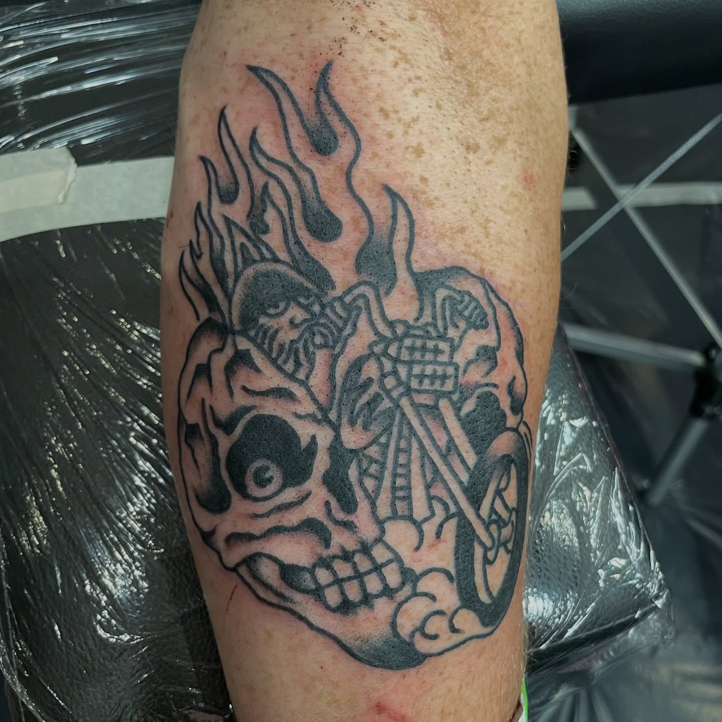 Skull and motorcycle black and grey tattoo on the forearm by Greg De Hoot, Youngsville, North Carolina