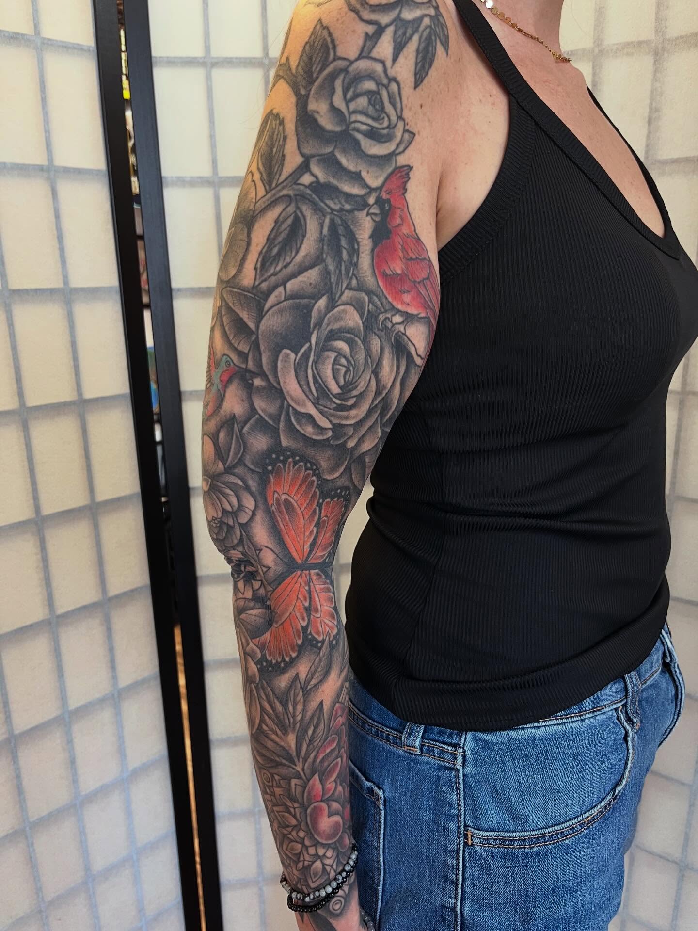 Roses and cardinal realism tattoo on the upper arm by Danielle Lorandeau