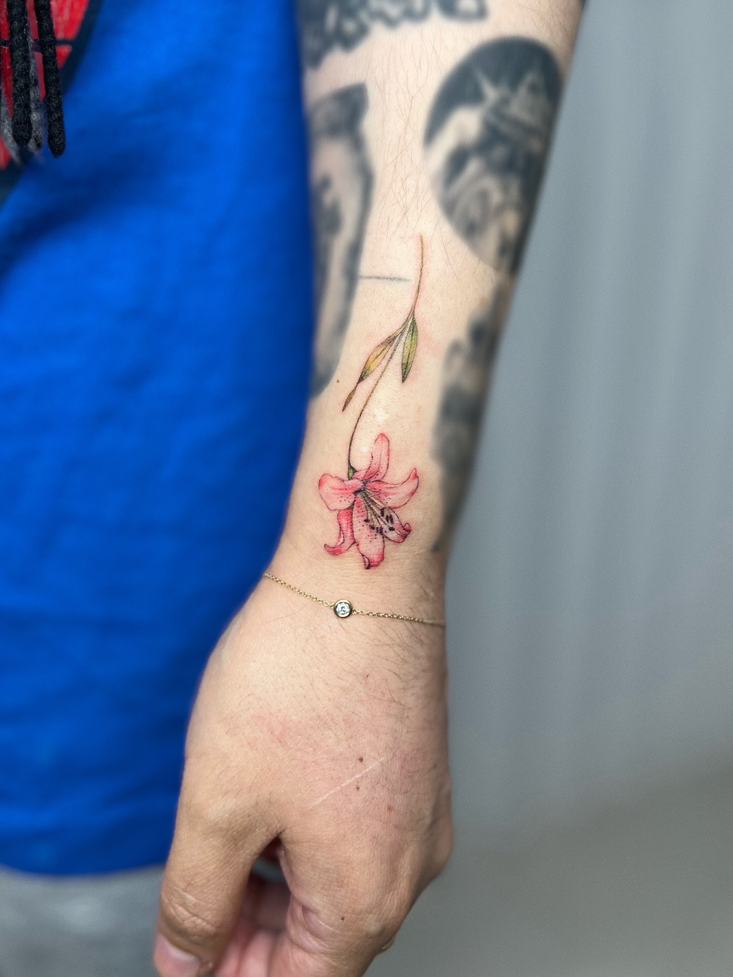 Pink lily watercolor tattoo on the forearm by Soy 🫛