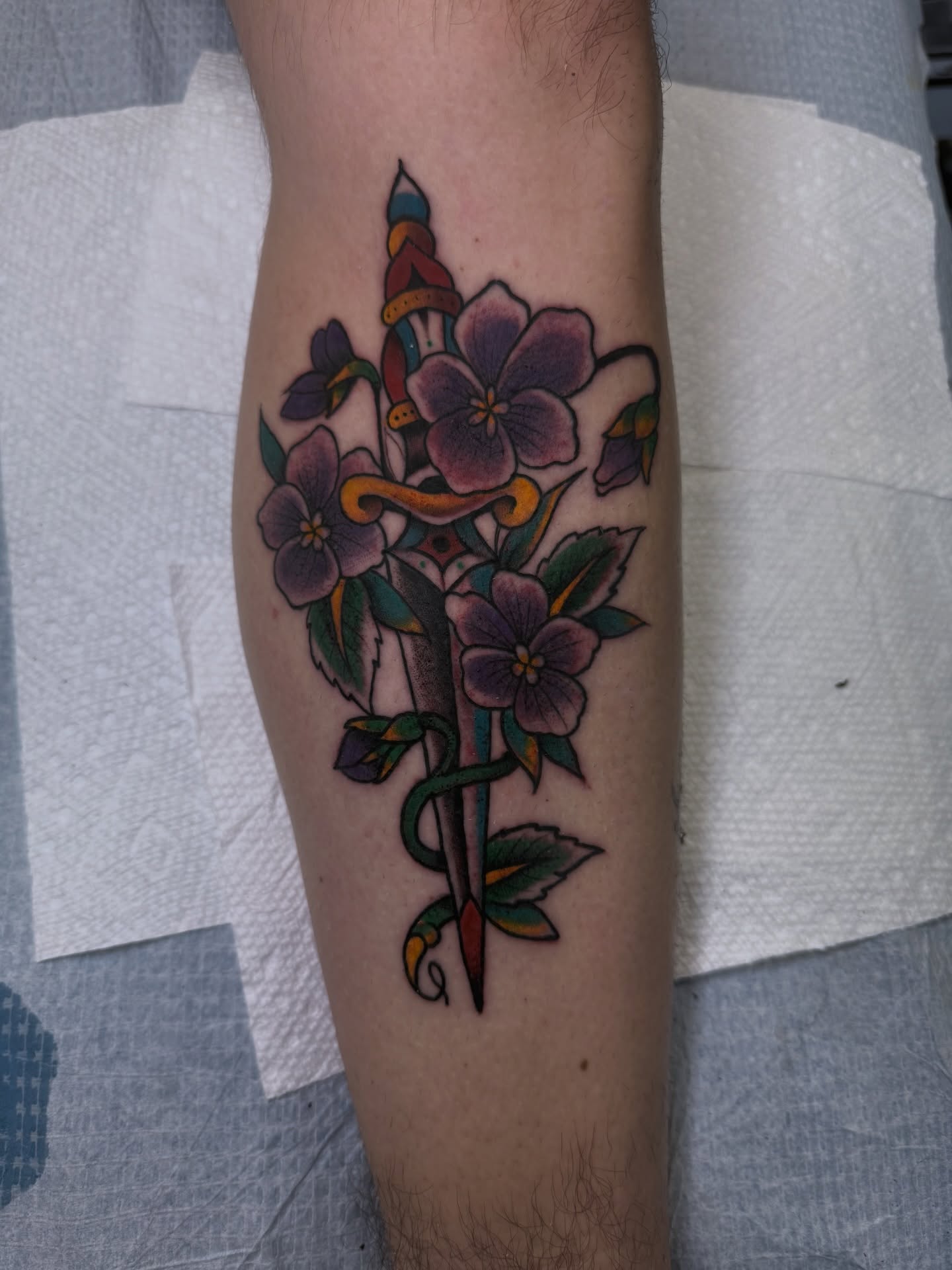 Flower and dagger American traditional tattoo on the forearm by Ramón Silva