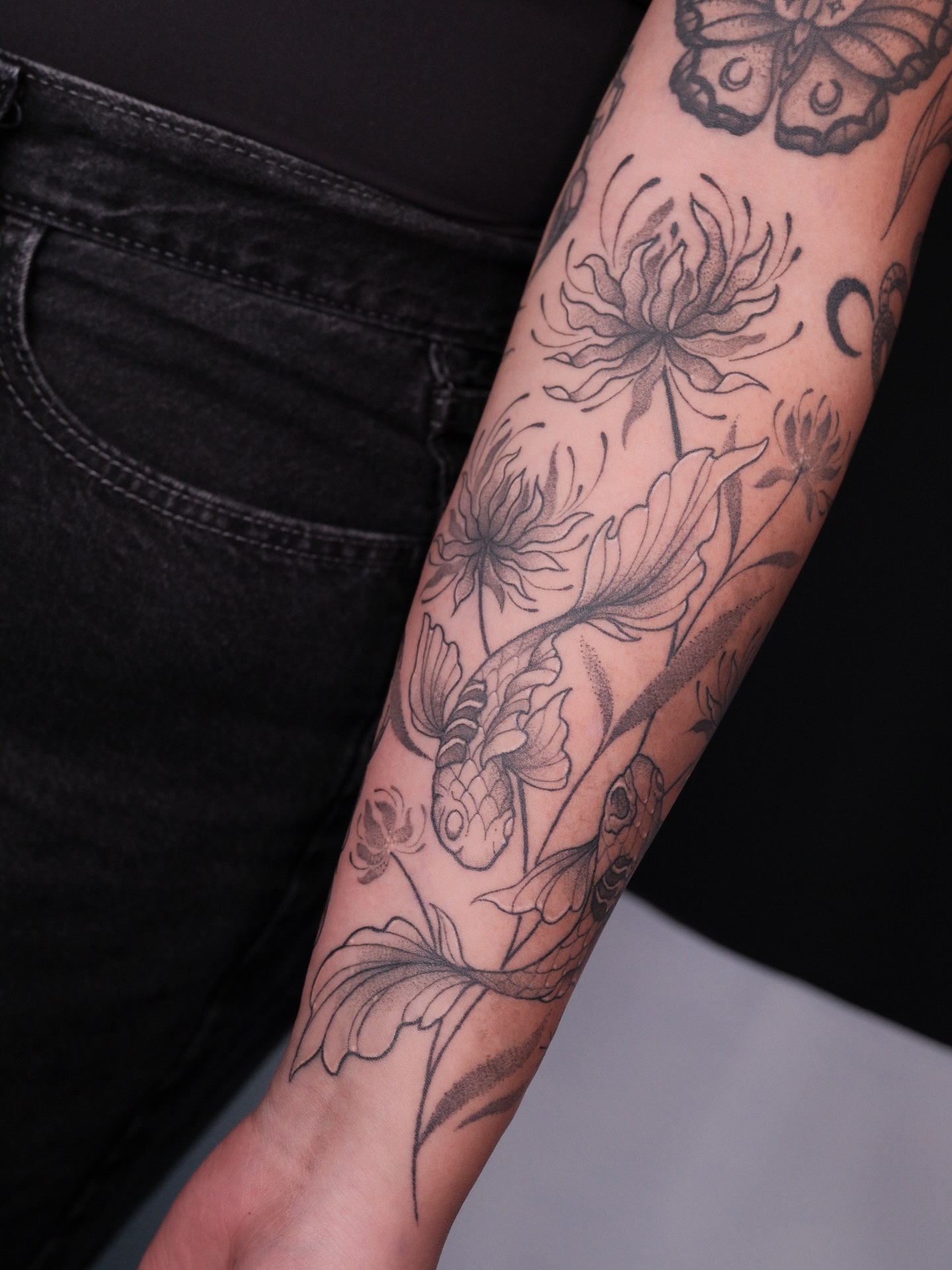 Koi fish and flowers black and grey tattoo on the forearm by Velvet, Seattle, Washington