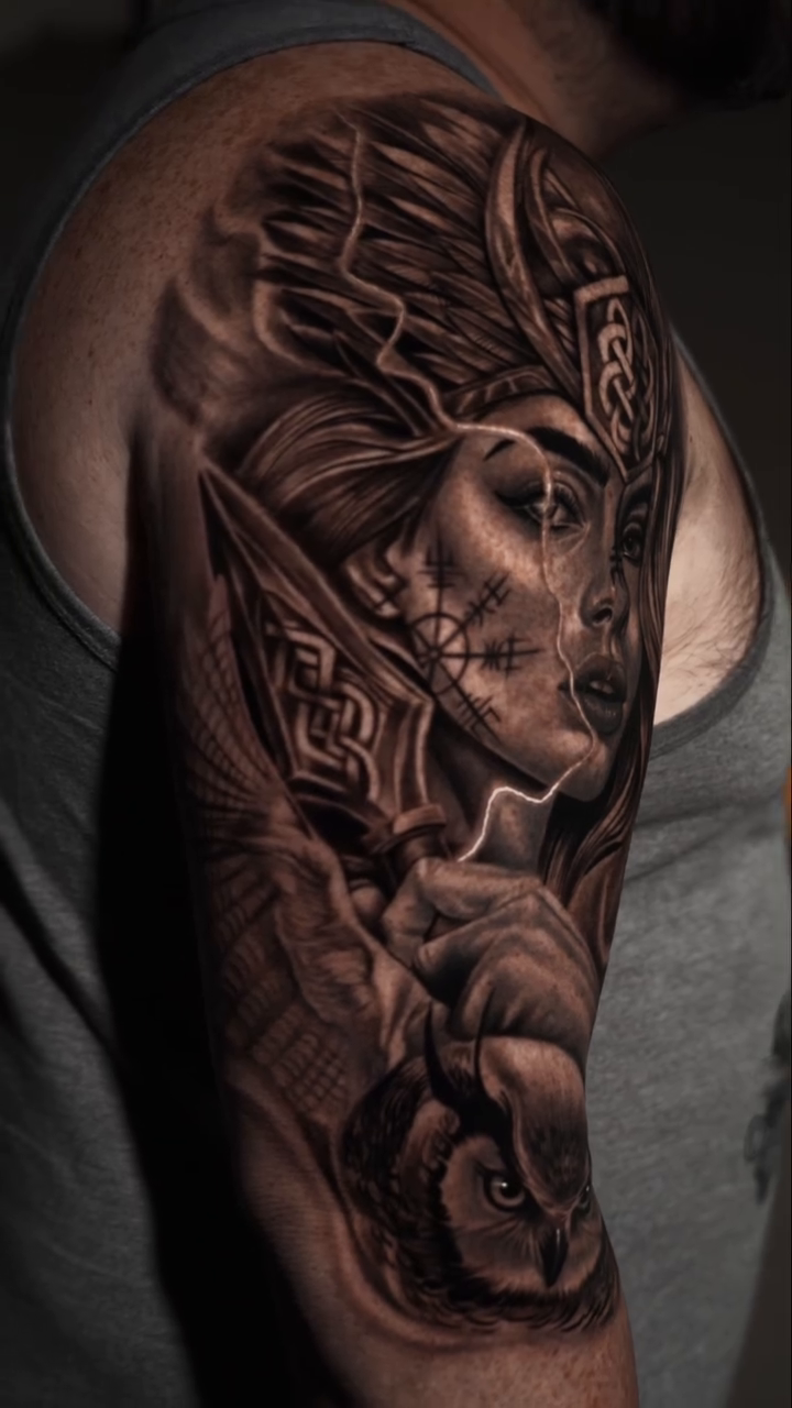Valkyrie with owl realism tattoo on the upper arm by Baxtertattoo