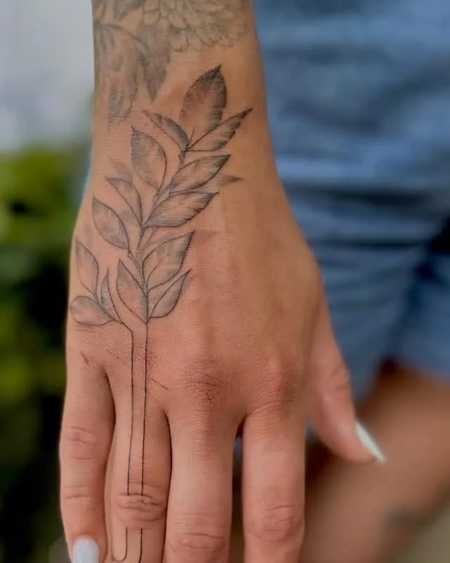 Leafy branch fine line tattoo on the hand by Raheem Jacobs, Austin, Texas